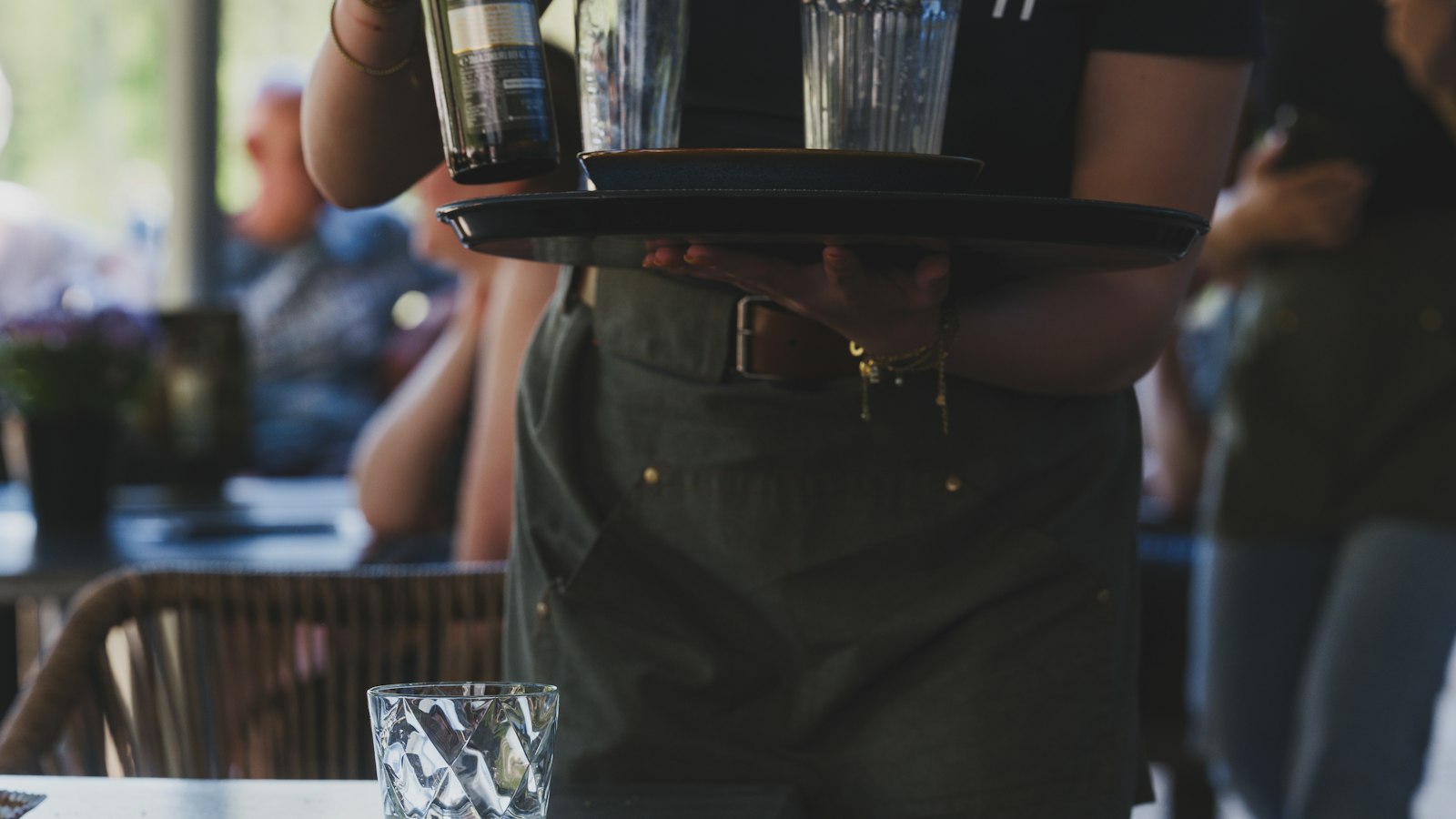 Serveur portant un plateau de verres en salle : la période d'essai en HCR