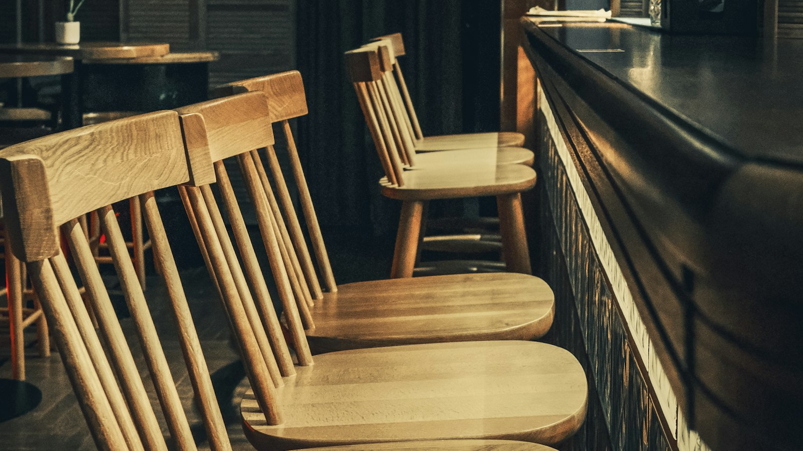Tabourets de bar vides alignés le long d'un comptoir : l'indemnité de licenciement en HCR