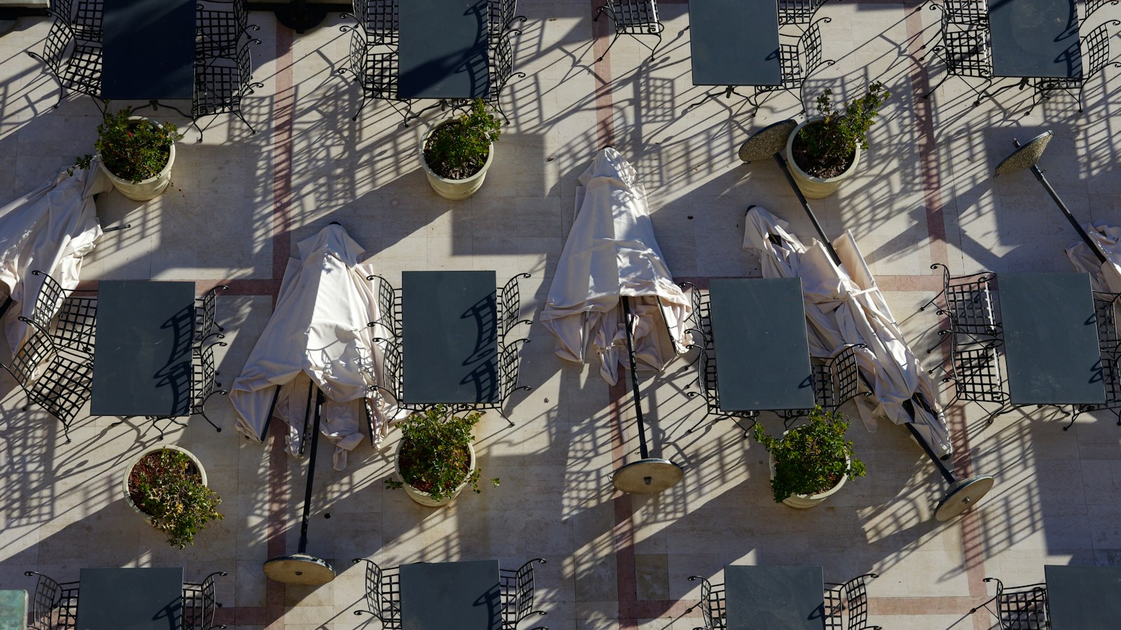 Terrasse de café aux parasols pliés et aux tables inoccupées : la fermeture annuelle ou saisonnière de l'établissement
