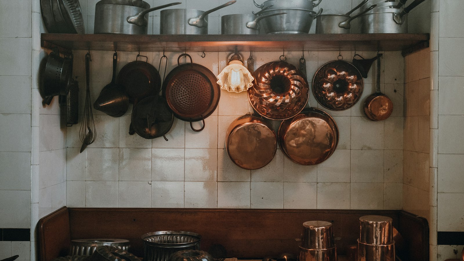 Casseroles et moules en cuivre alignés au mur d'une cuisine : le contingent d'heures supplémentaires en HCR