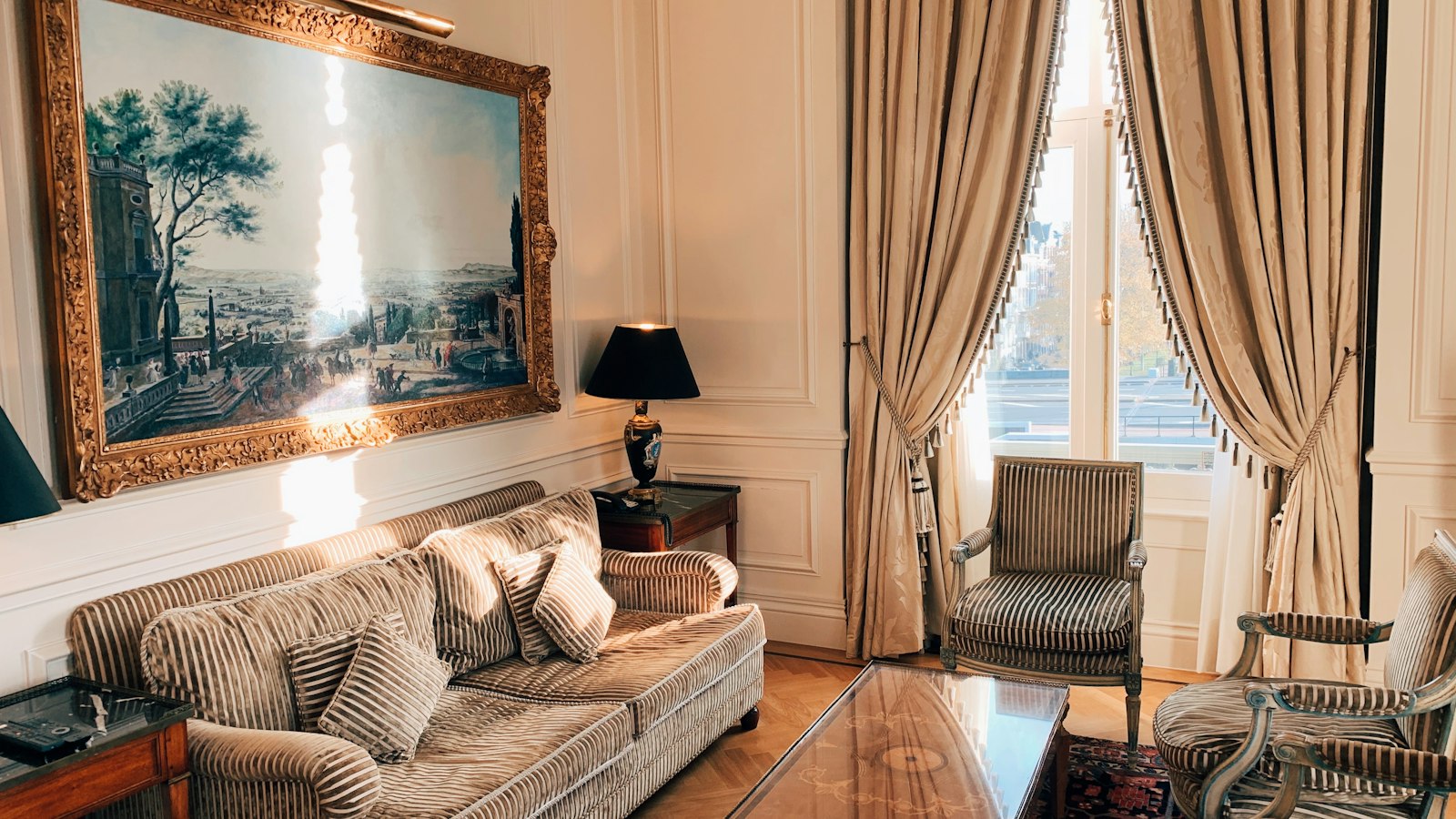 Salon d'une suite d'hôtel parisien aux rideaux de soie : la location-gérance et le mandat de gestion hôtelière