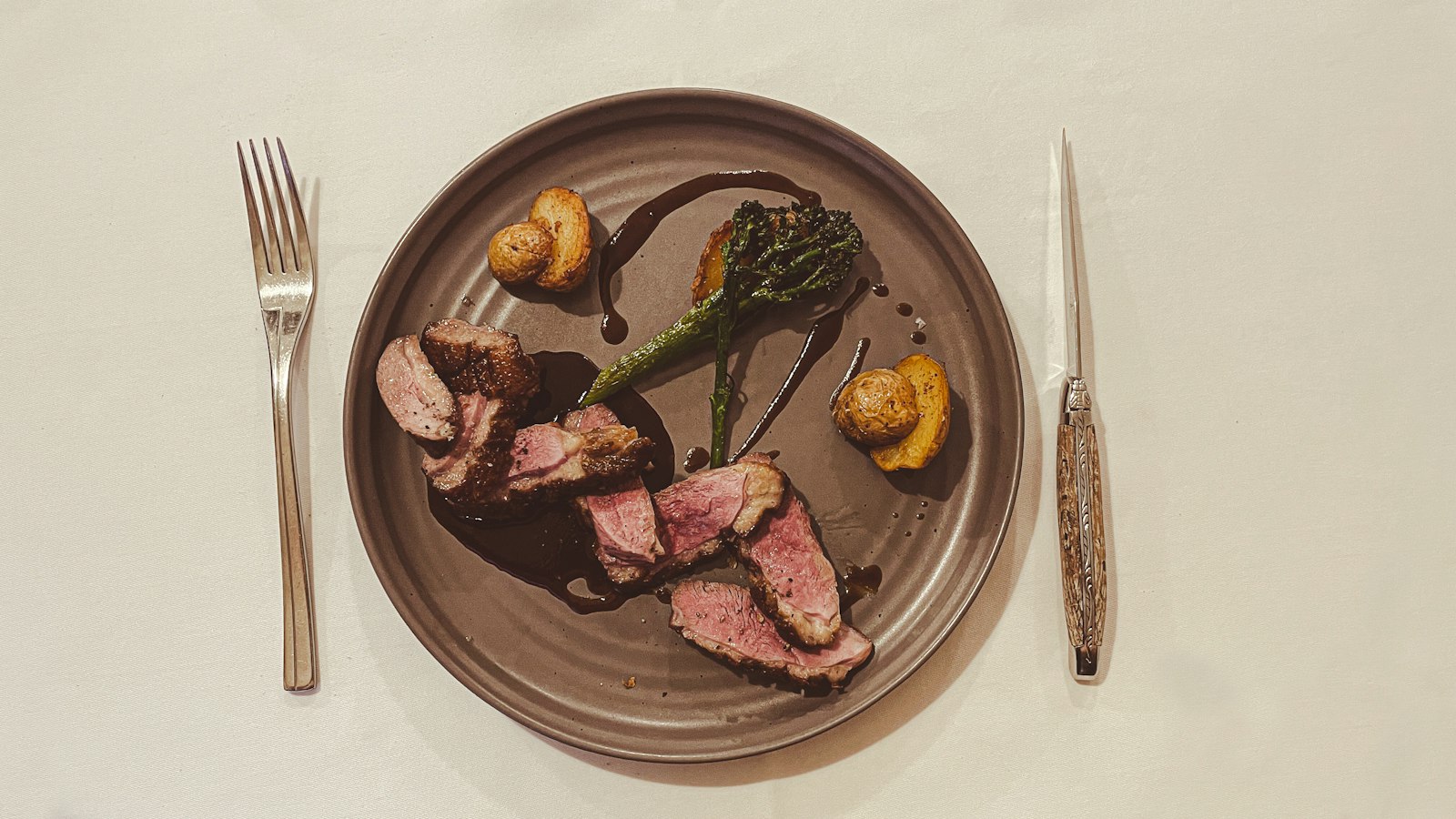 Assiette de viande et de légumes dressée entre fourchette et couteau : l'indemnité compensatrice de nourriture