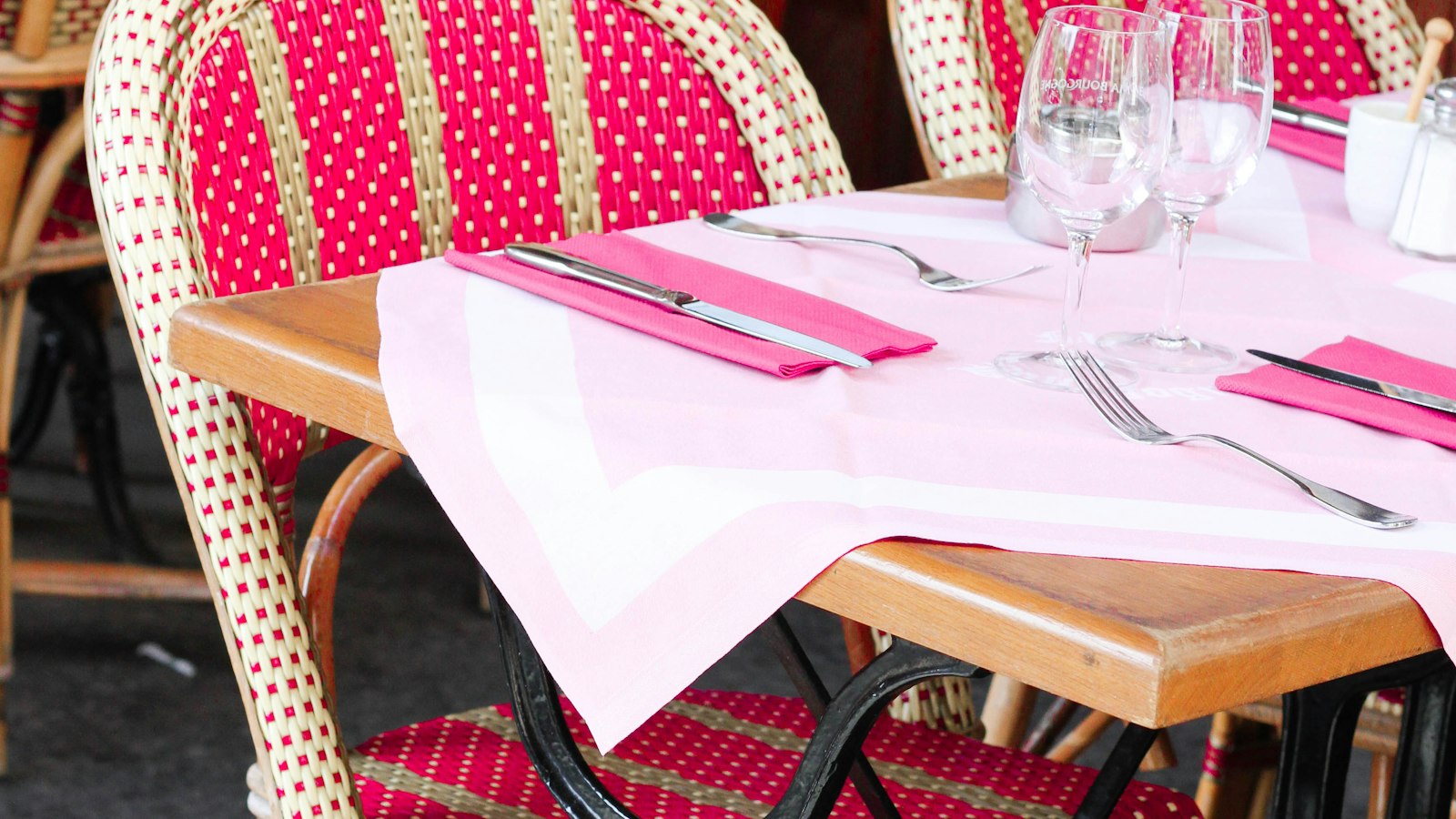 Table de bistrot dressée et chaises en rotin sur une terrasse parisienne : la rémunération au pourcentage service