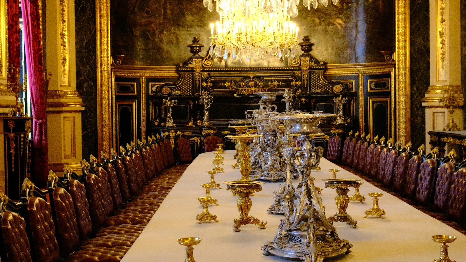 Longue table dressée sous un lustre de cristal dans un salon de réception : l'accord d'entreprise dans les hôtels, cafés, restaurants