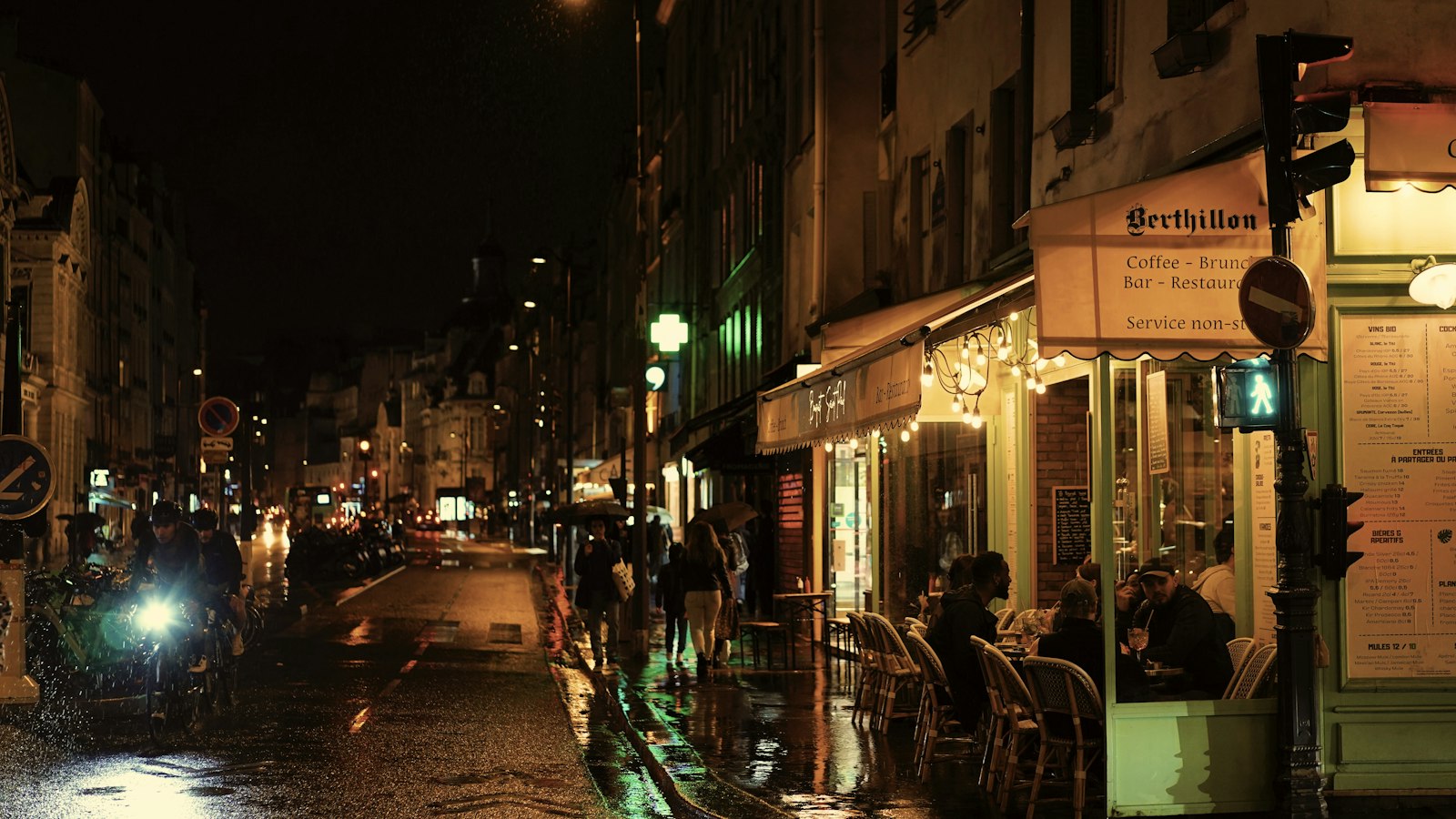 Terrasse de café dans une rue parisienne la nuit, sous la pluie : les violences et incivilités de la clientèle dans les hôtels, cafés, restaurants