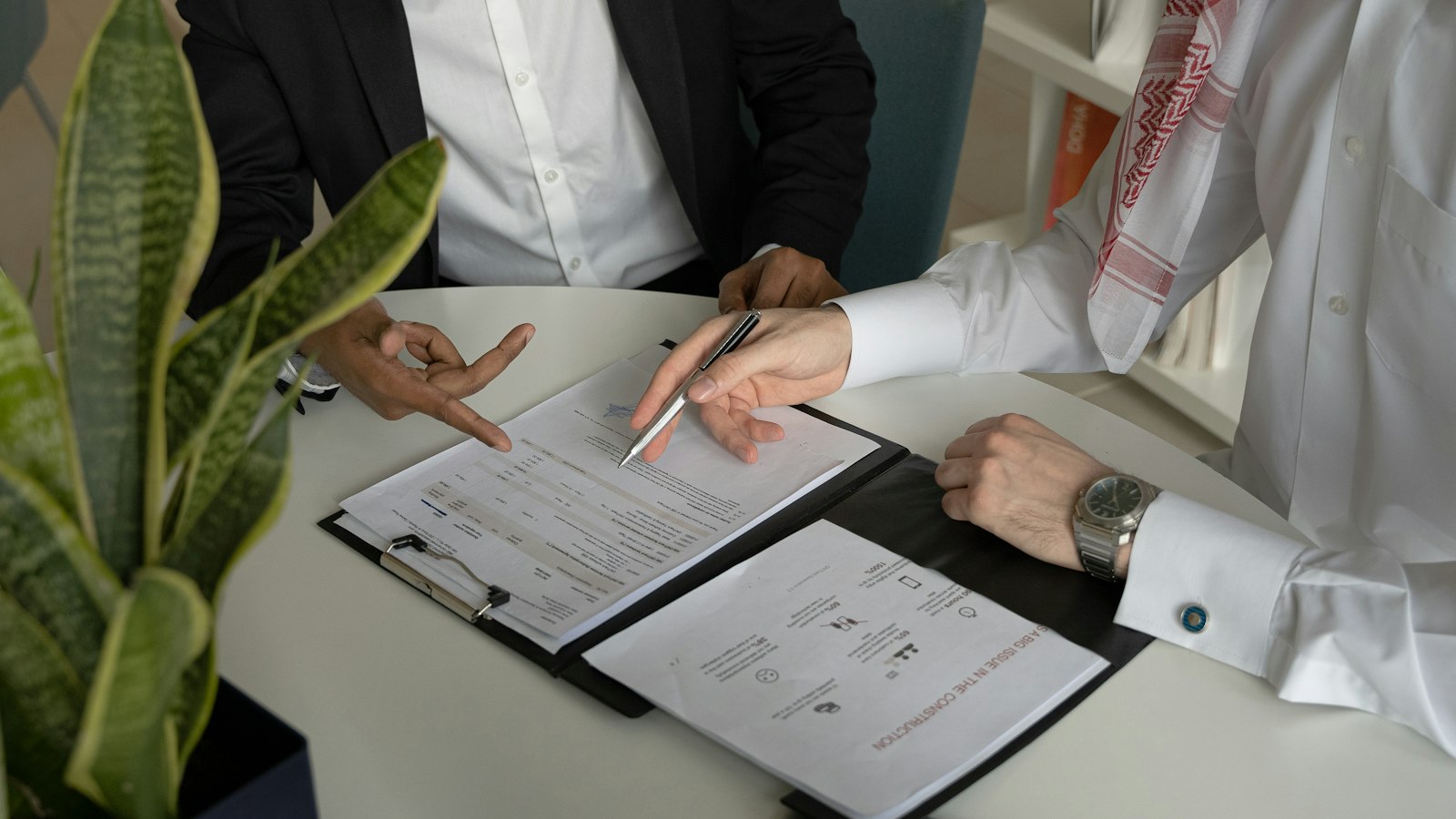 2 hommes à une table avec des documents et un stylo : la transaction avec un salarié dans les hôtels, cafés, restaurants