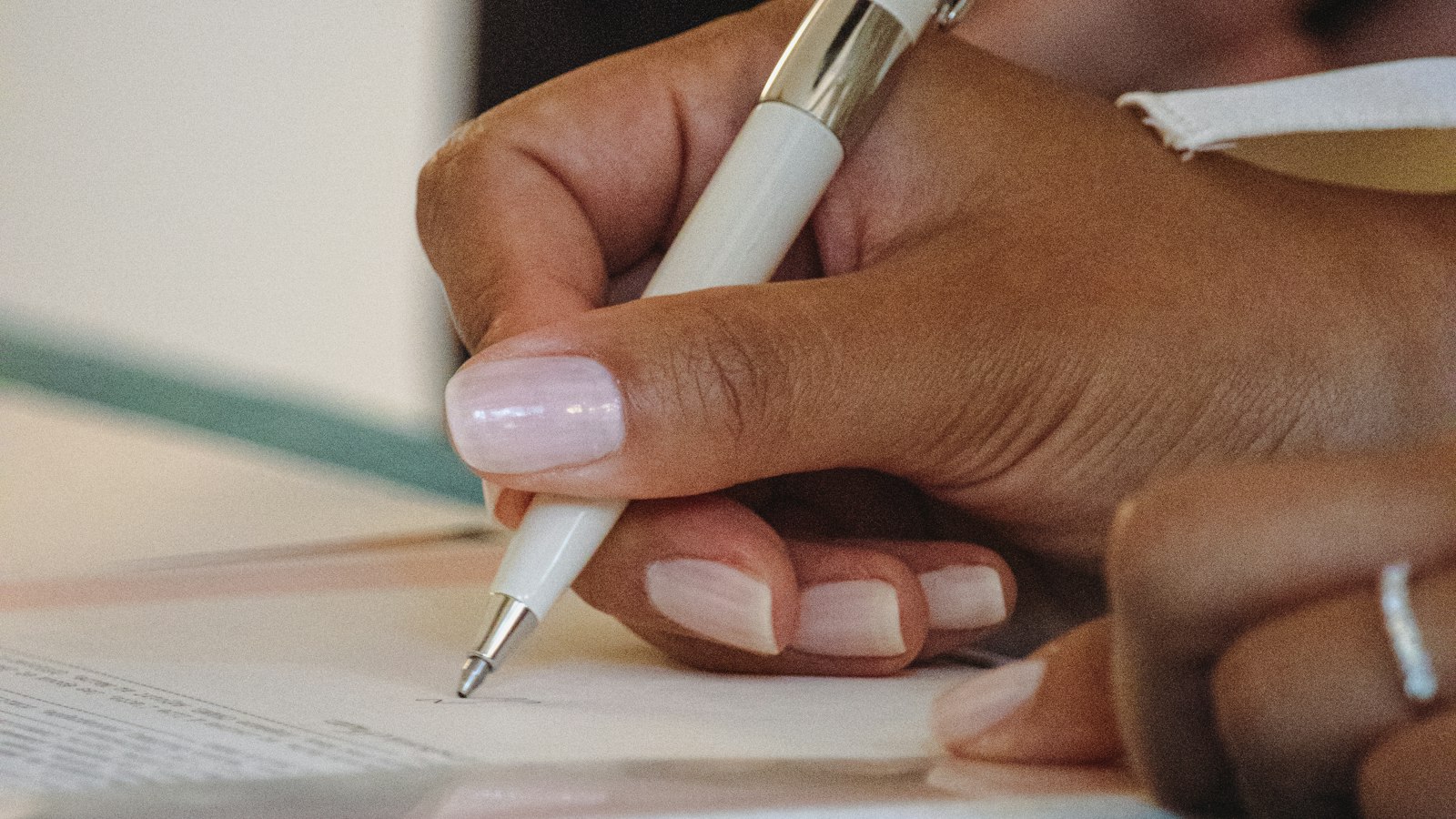 Main signant un document officiel au stylo : le contrat de travail du salarié dans les hôtels, cafés, restaurants