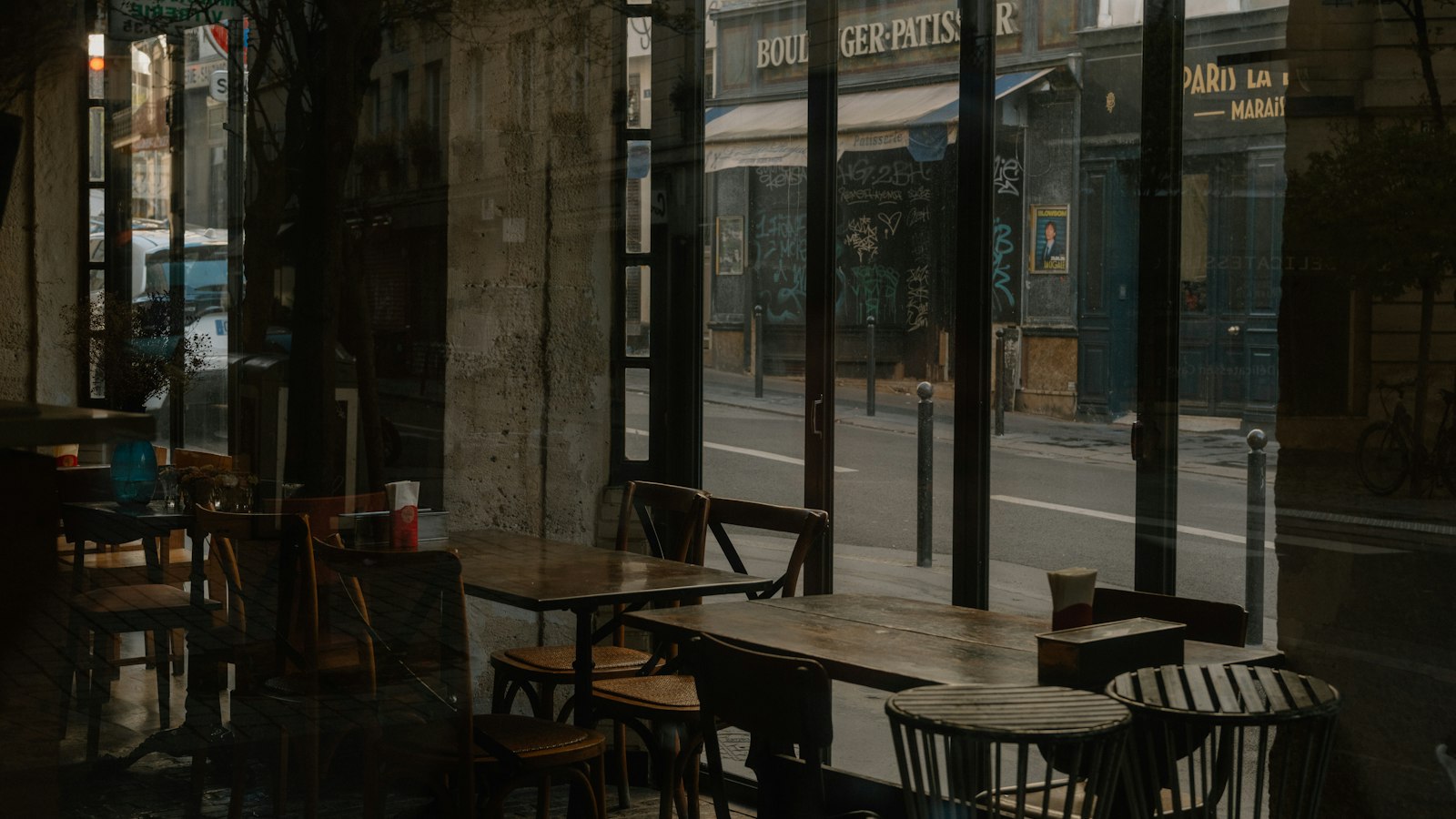 Tables et chaises vides d'un café reflétées dans une vitre : l'inaptitude d'un salarié dans les hôtels, cafés, restaurants