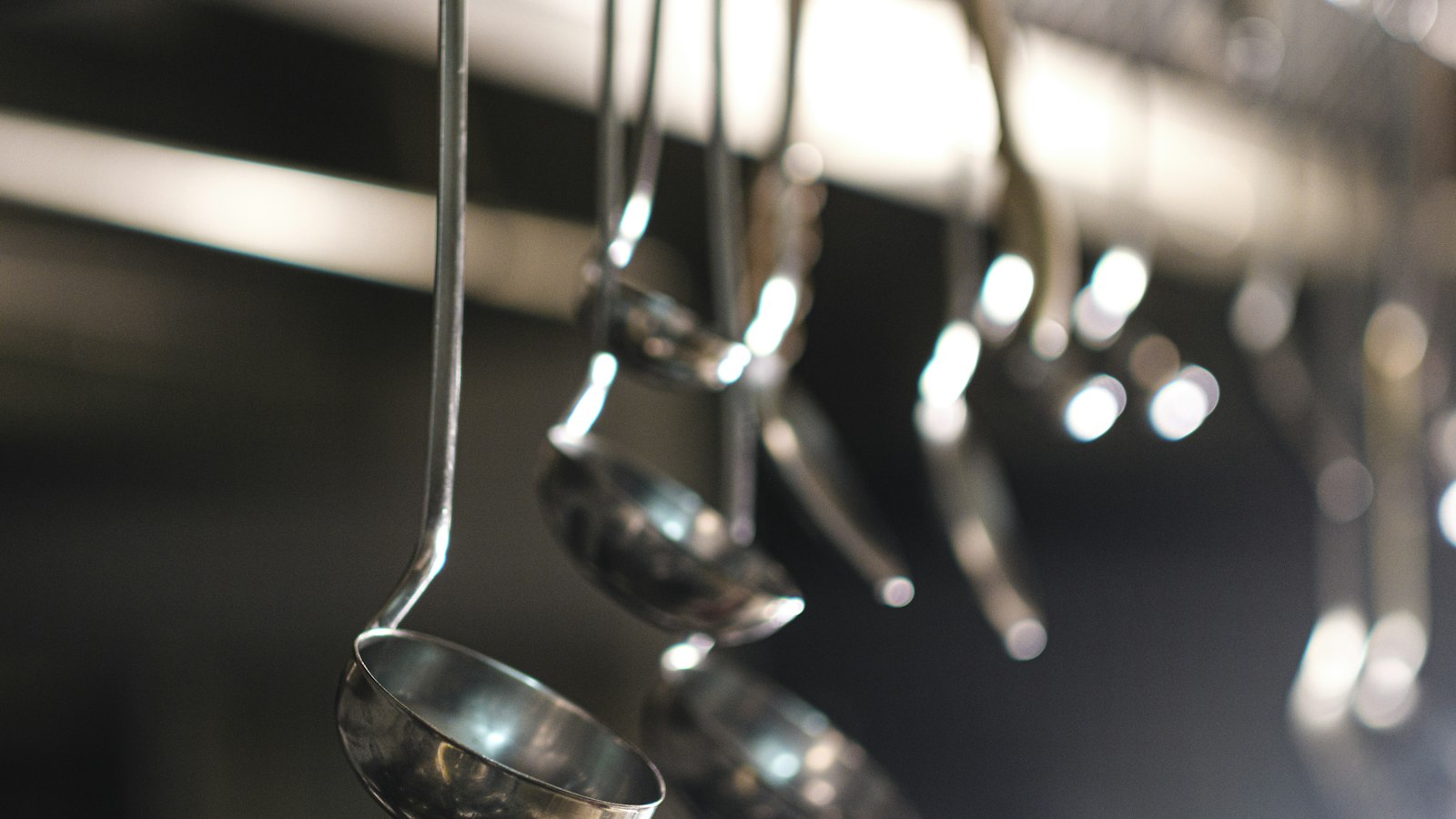 Louches en inox suspendues dans une cuisine professionnelle : le document unique dans les hôtels, cafés, restaurants