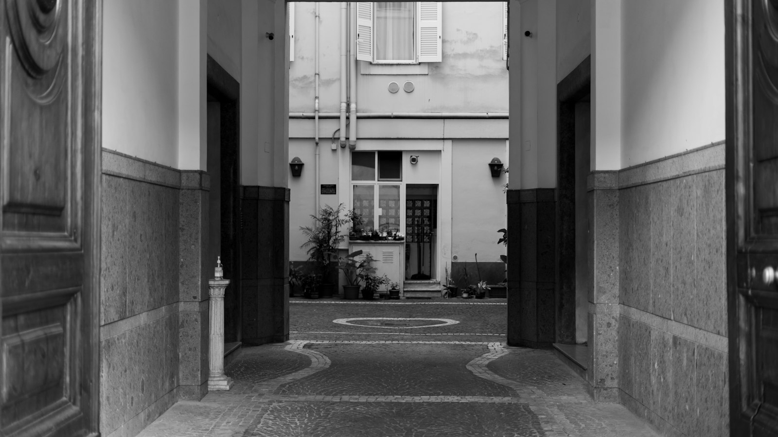 Cour d'immeuble déserte en noir et blanc : les questions fréquentes des employeurs dans les hôtels, cafés, restaurants