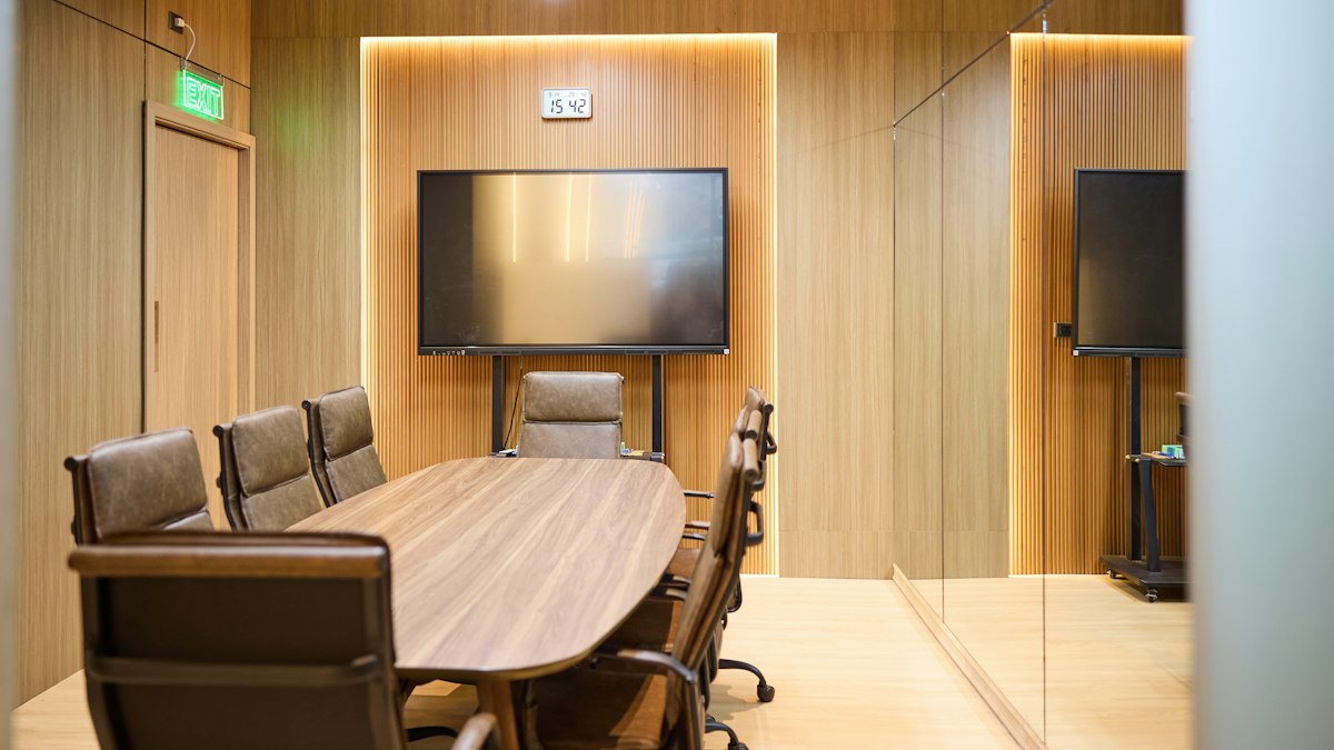 Salle de réunion boisée avec table ovale : le CSE et le dialogue social dans la sécurité privée