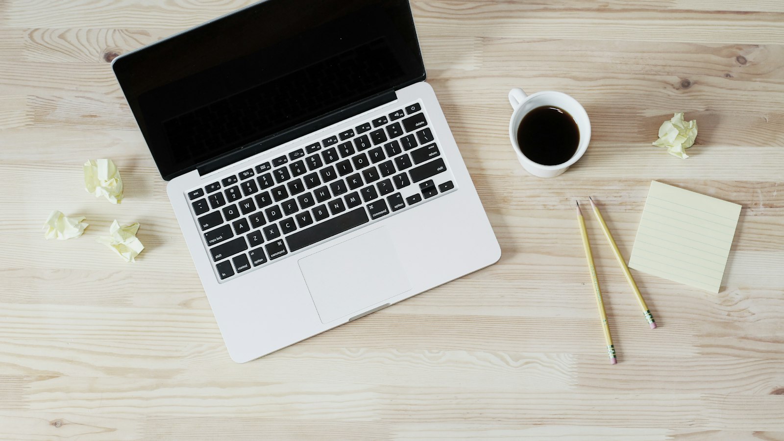 Ordinateur portable et bloc-notes sur un bureau en bois : les ressources pratiques de l'employeur
