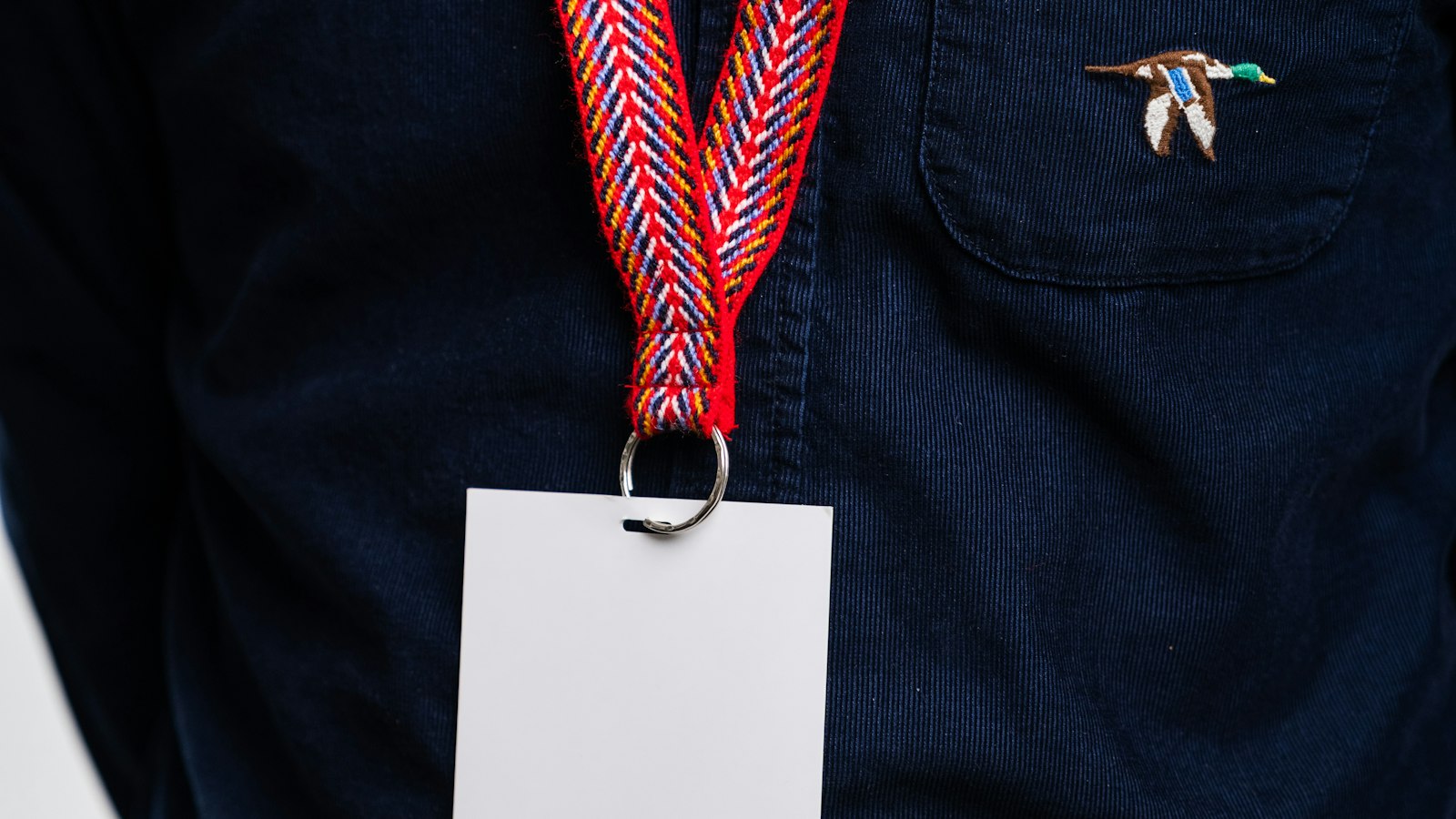 Porte-badge vierge porté sur une chemise sombre : la carte professionnelle de l'agent de sécurité