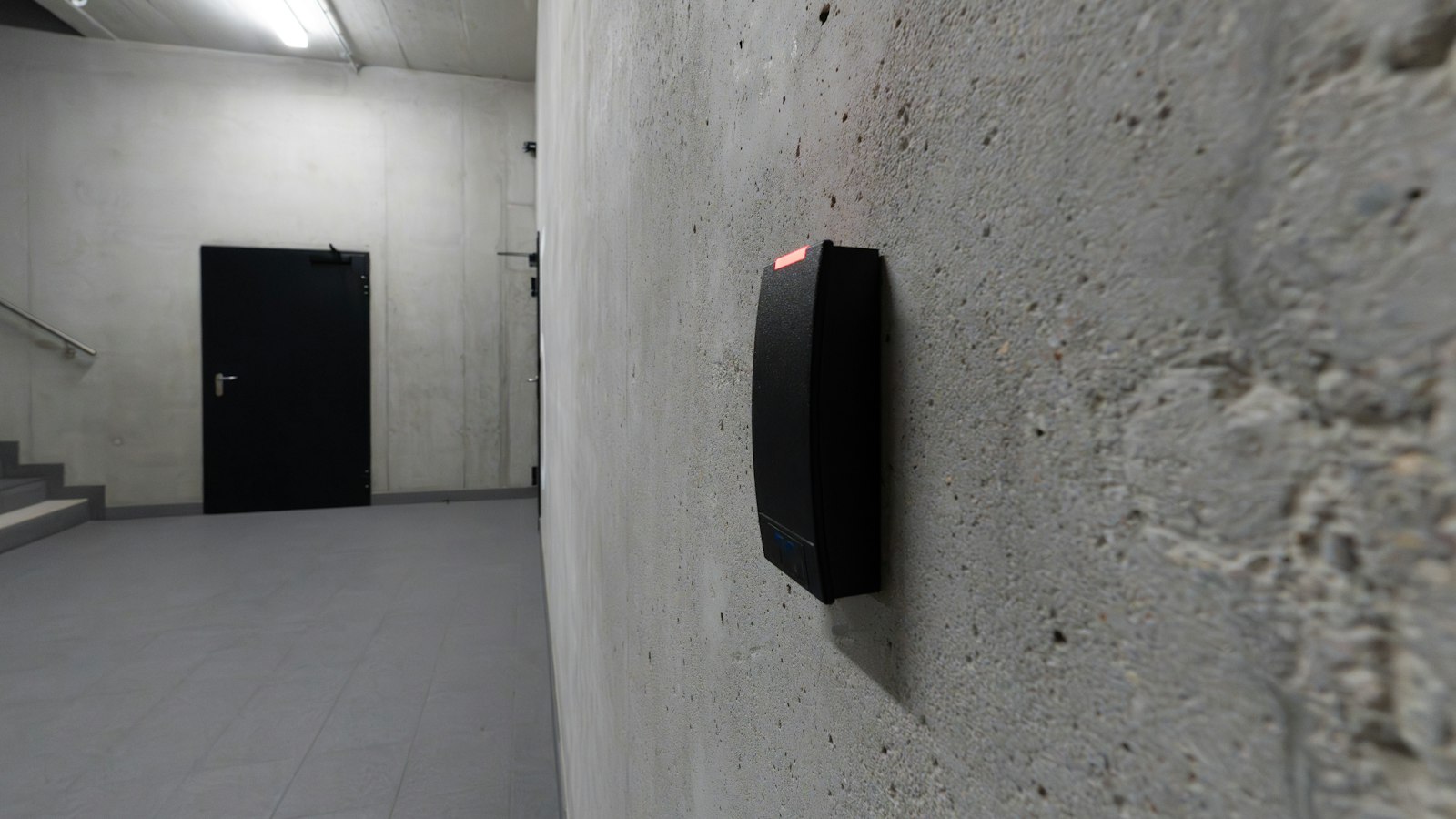 Lecteur de badge sur un mur de béton à l'entrée d'un couloir de service : la suspension ou le retrait de la carte professionnelle