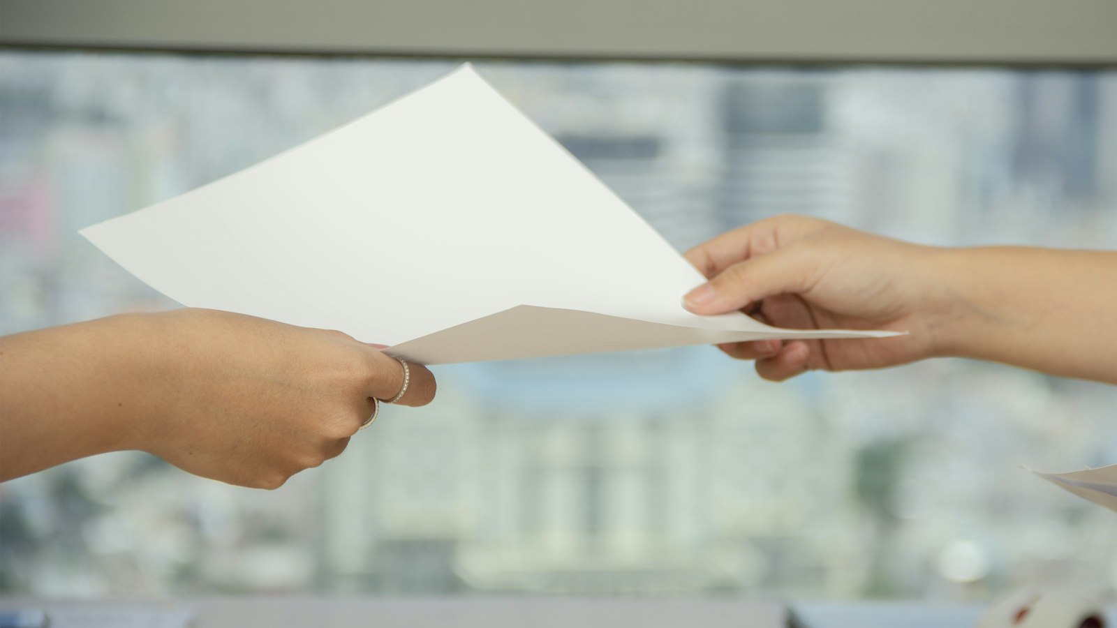 Remise d'un document entre deux mains : la liste du personnel et les pièces à transmettre