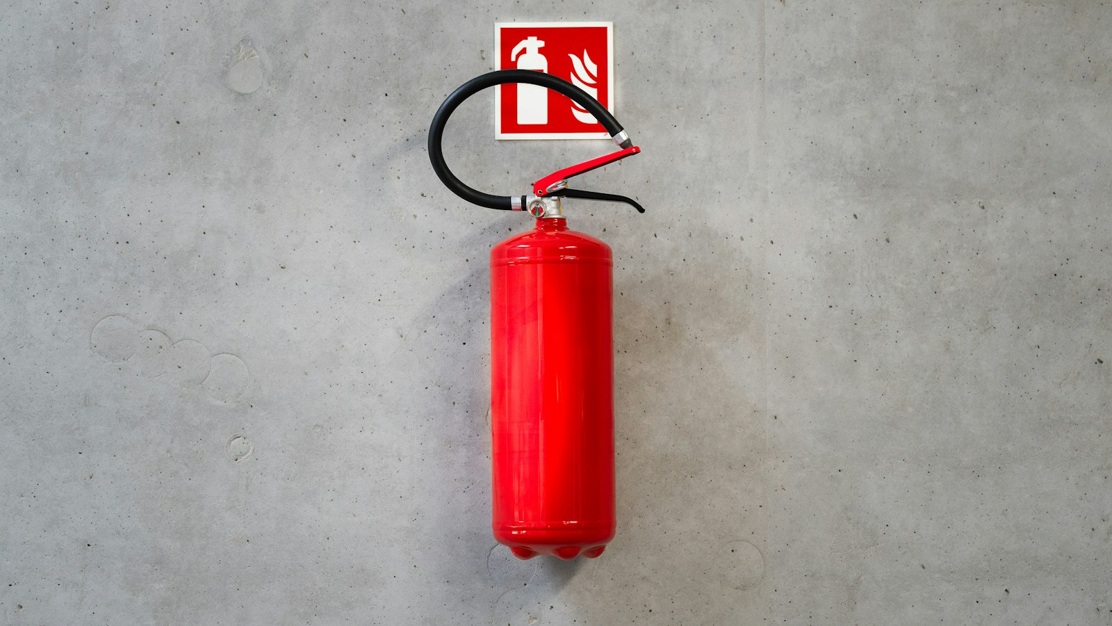 Extincteur rouge sur un mur de béton : le document unique et le plan de prévention sur site