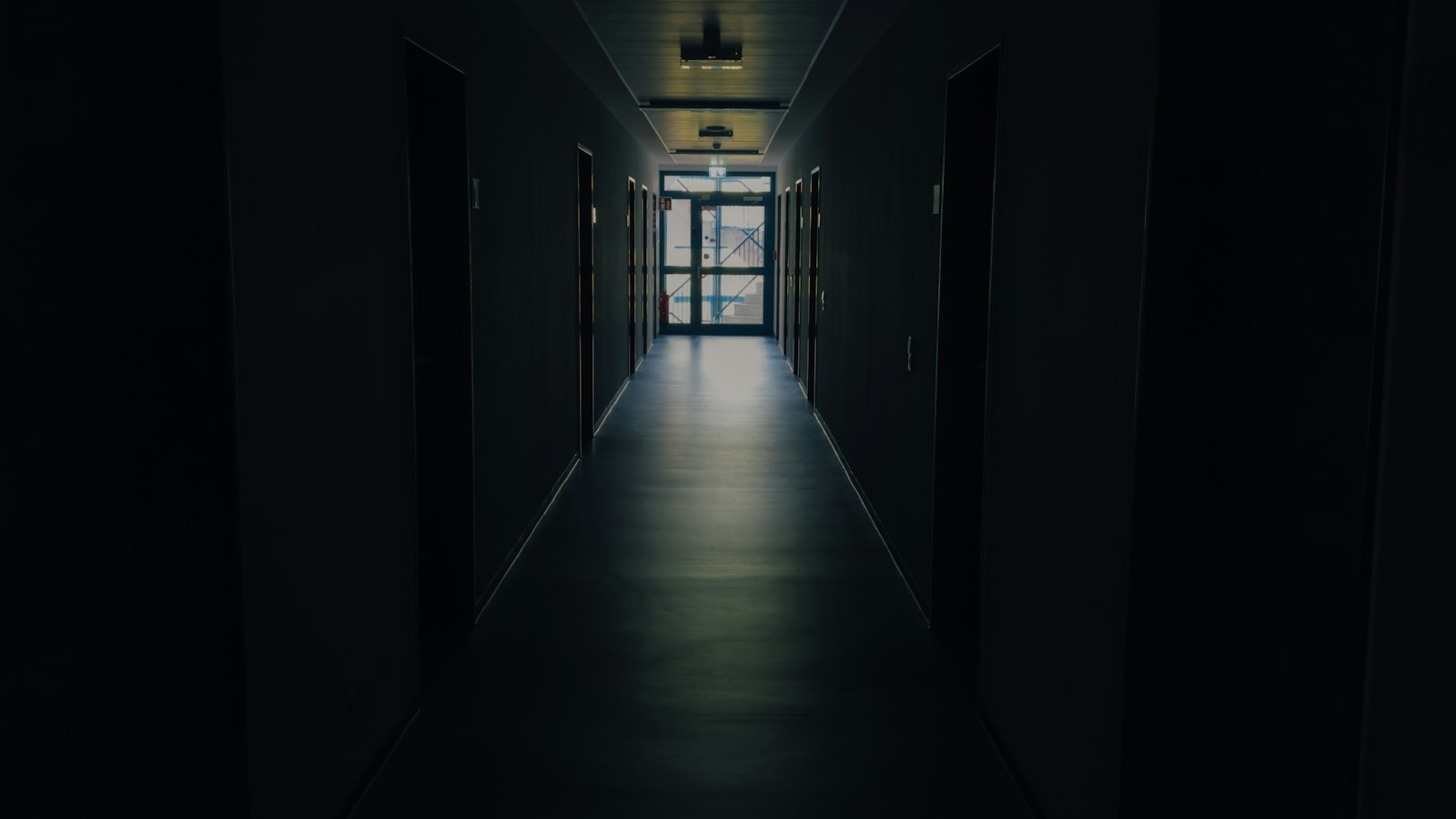 Couloir sombre éclairé au fond : le harcèlement et les agissements sexistes
