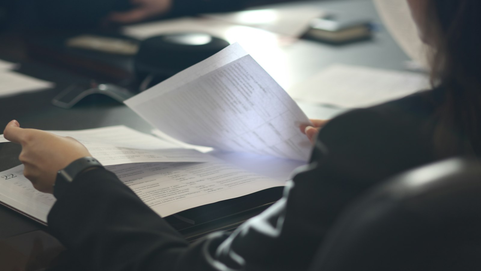 Personne lisant un document à une table : la discipline et la rupture du contrat en cinéma
