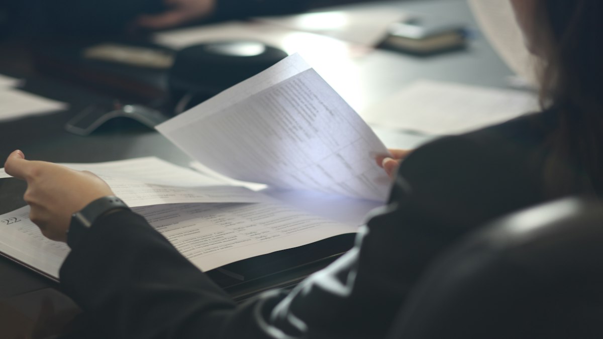 Personne lisant un document à une table : la discipline et la rupture du contrat en cinéma