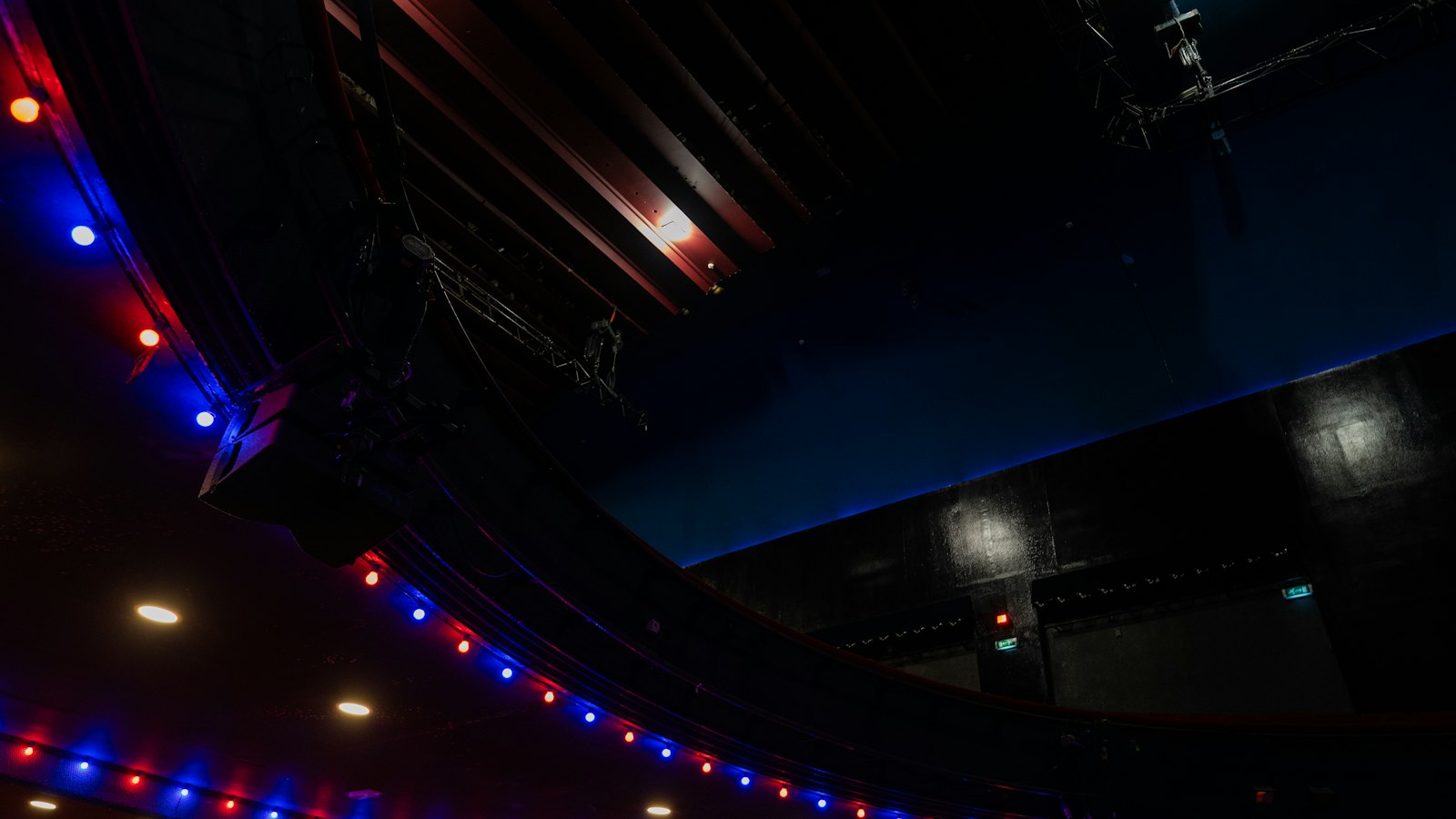 Salle vide aux fauteuils rouges sous un éclairage coloré : embauche et contrat de travail dans une salle de cinéma