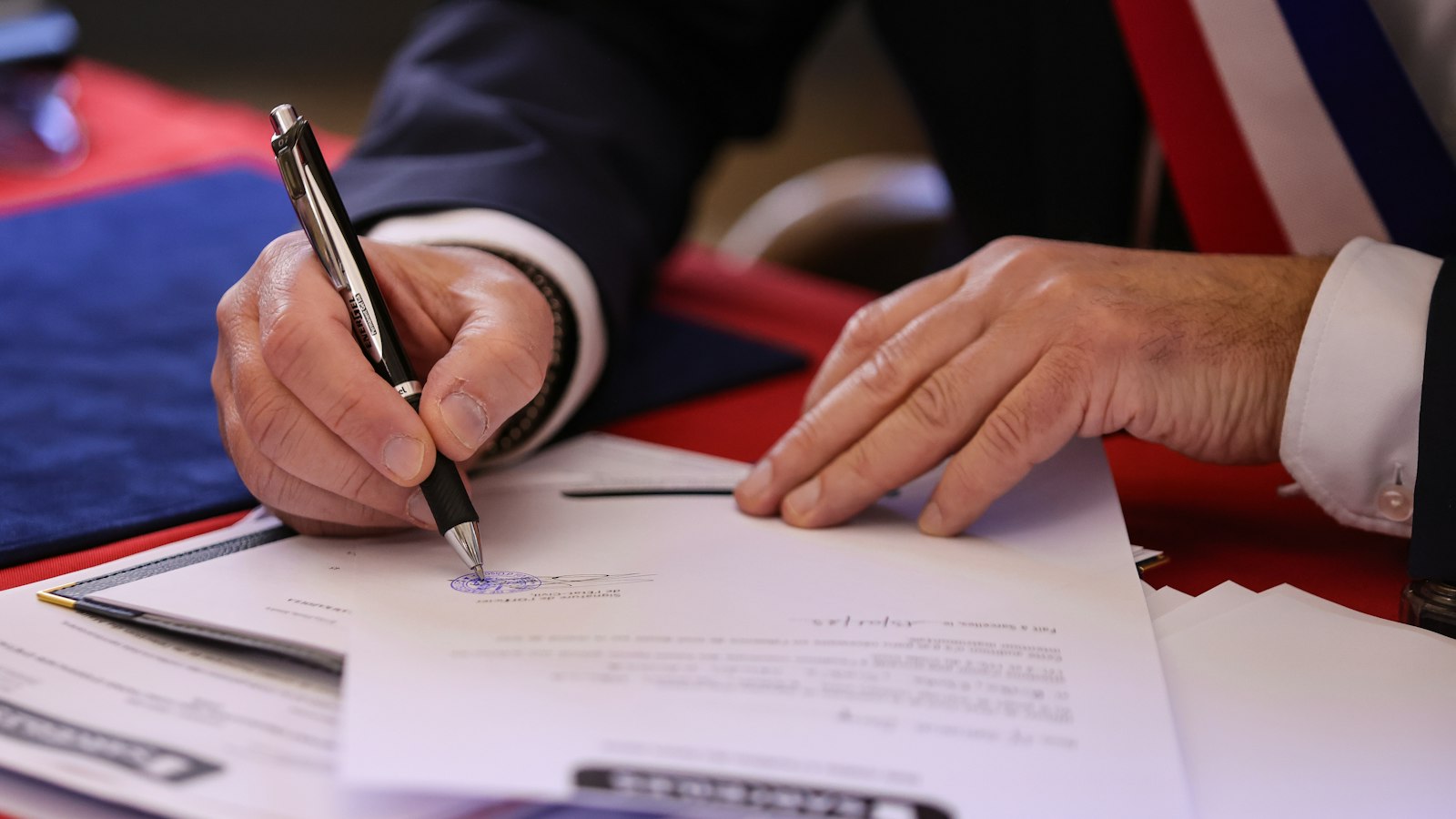 Élu portant l'écharpe tricolore signant un document : le cinéma en délégation de service public et la reprise en régie