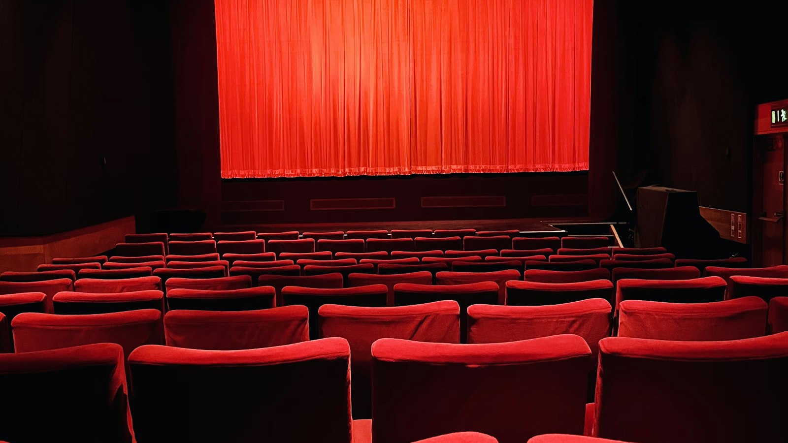 Salle de cinéma vide aux fauteuils rouges après la dernière séance : congés payés et fermeture d'un cinéma