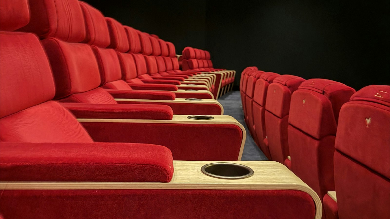 Fauteuils rouges vides face à un écran éteint : les coupures et le repos quotidien en cinéma