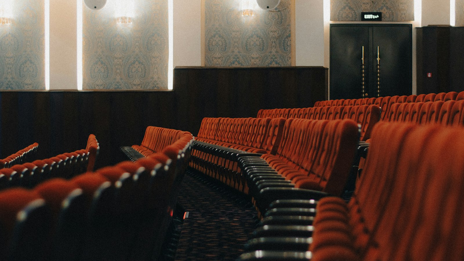 Fauteuils de velours rouge vides dans une salle classique : le licenciement économique dans un cinéma