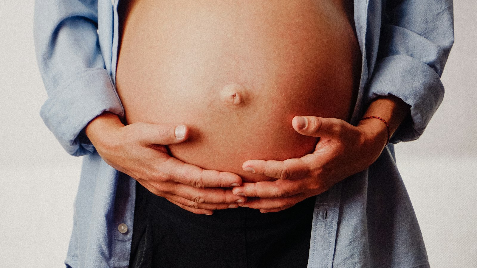 Femme enceinte tenant son ventre entre ses mains : maternité, paternité et enfant malade en cinéma