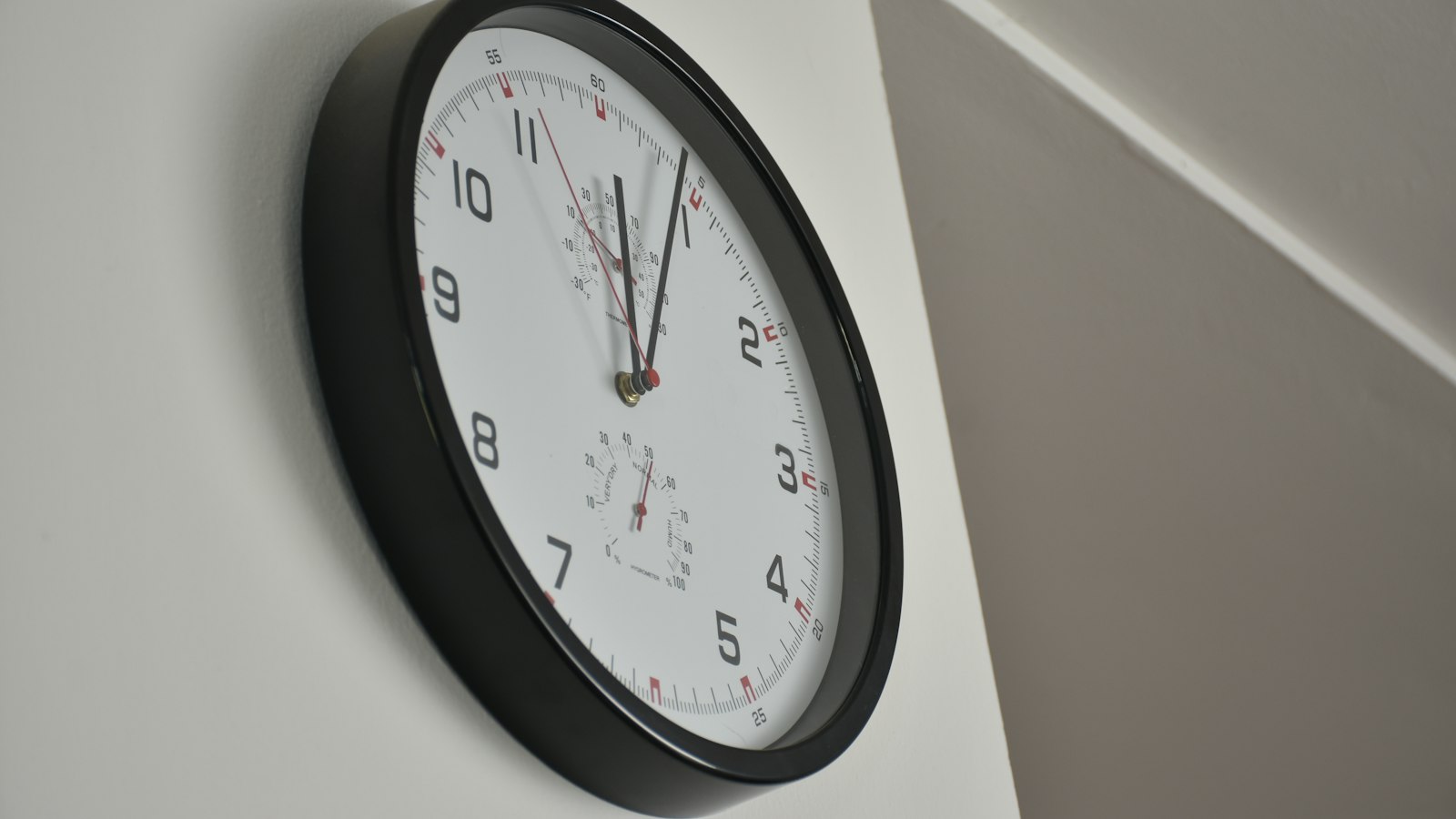 Horloge murale sur un mur blanc : planning et décompte des heures en cinéma