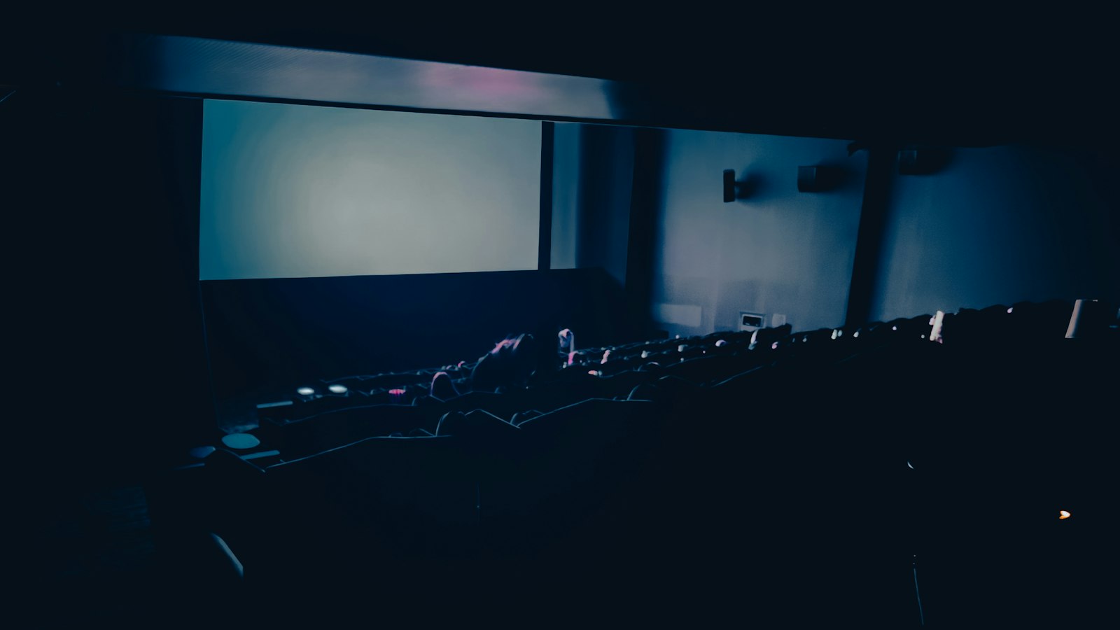 Salle vide devant un écran éclairé : le travail du dimanche dans un cinéma