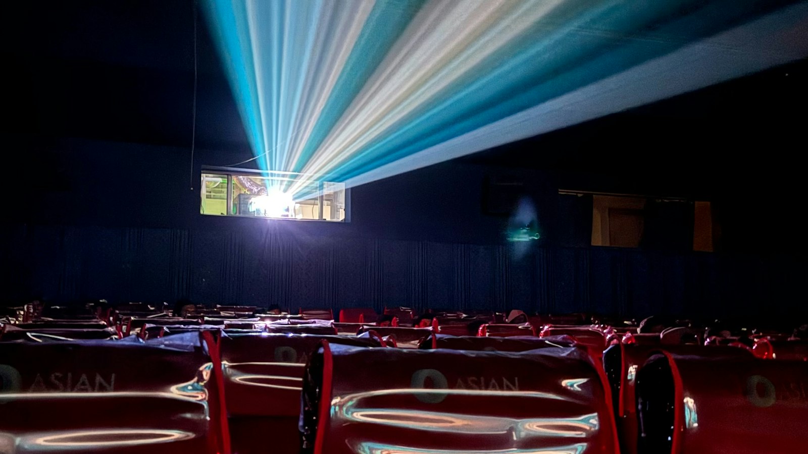 Faisceaux de projection dans une salle de cinéma vide : le travail après minuit et le travail de nuit en cinéma