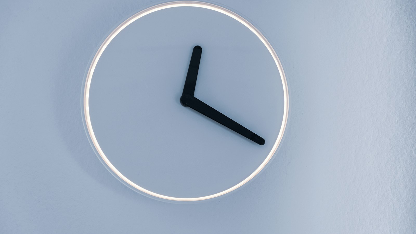 Horloge murale épurée sur fond bleu : la durée du travail et les heures supplémentaires en cinéma