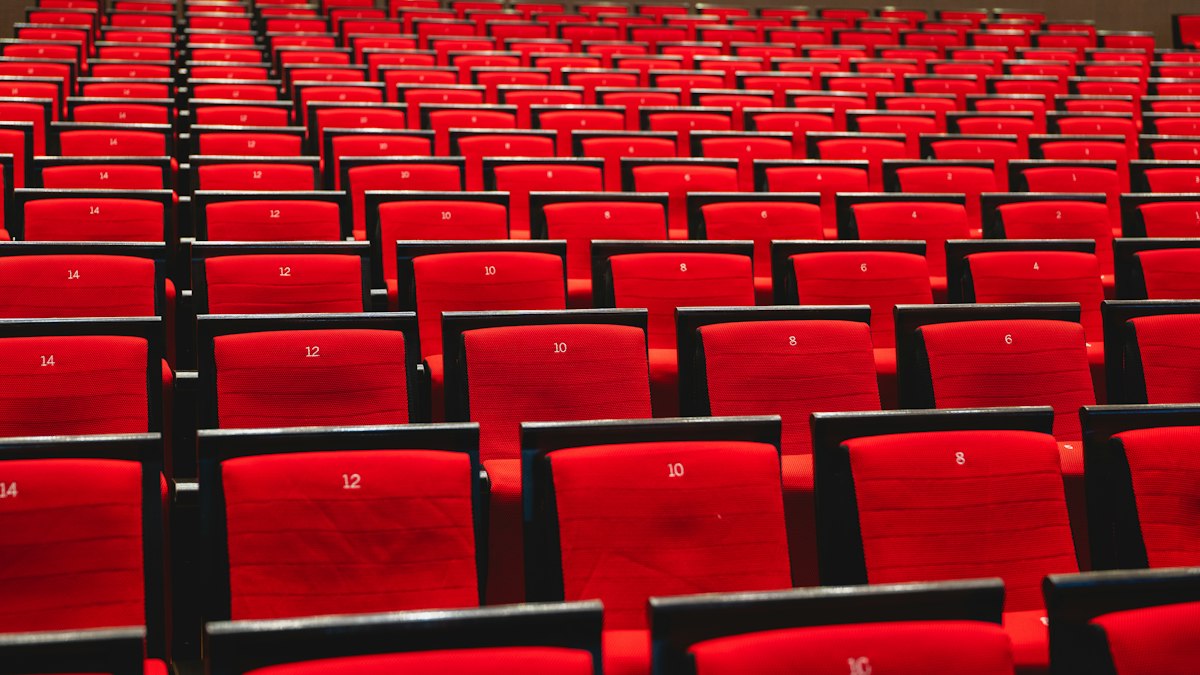 Rangées de fauteuils rouges en arc de cercle : le CSE et le dialogue social dans les cinémas