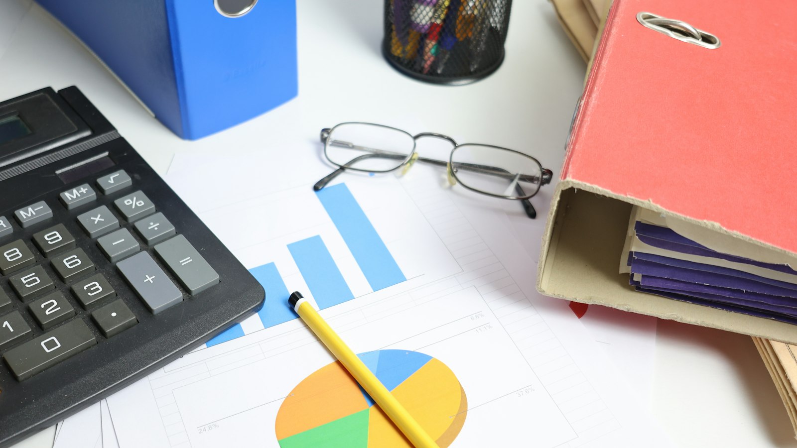 Classeurs, calculatrice et graphiques sur un bureau : ressources de l'employeur de la propreté