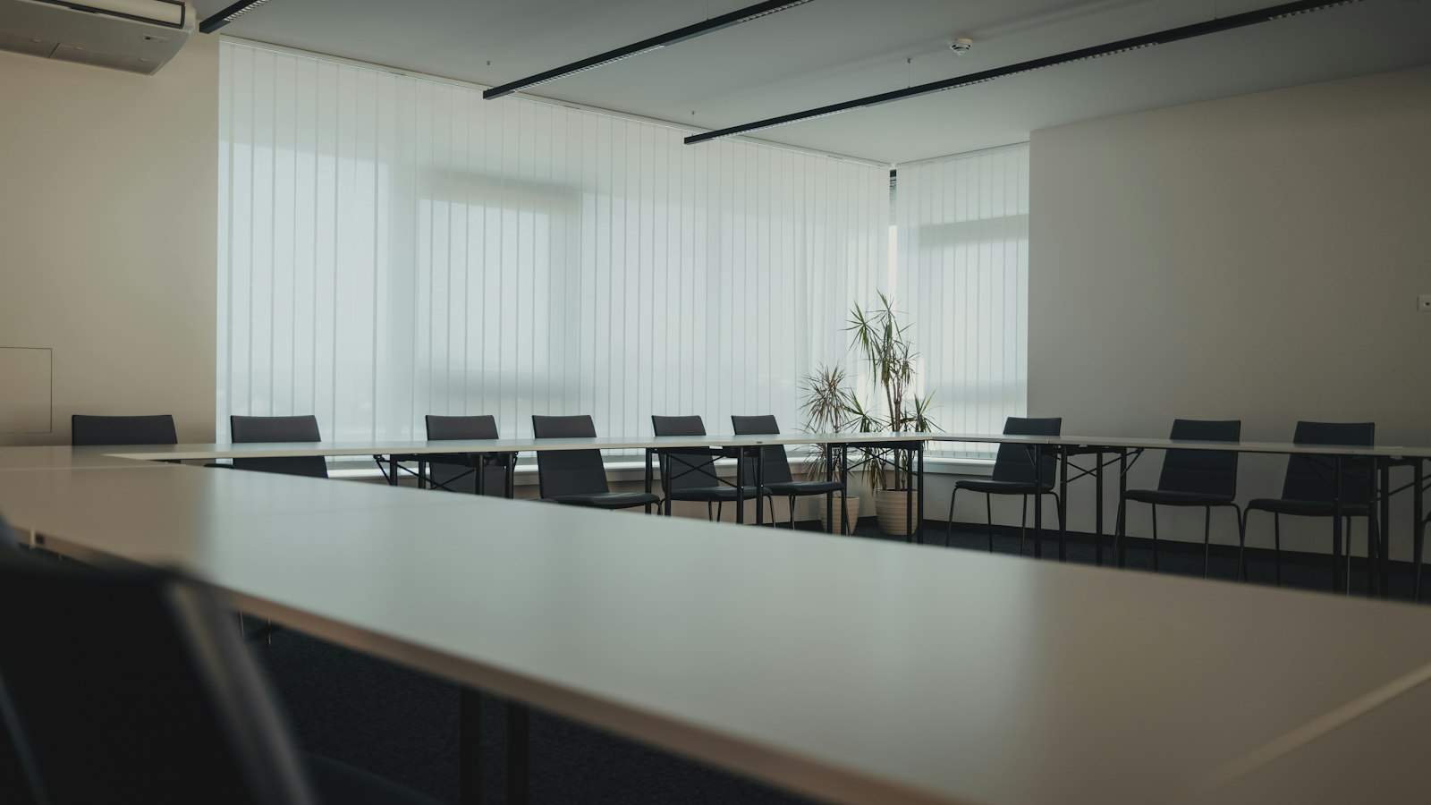 Salle de réunion vide avec une longue table et des chaises alignées : accord d'entreprise dans la propreté