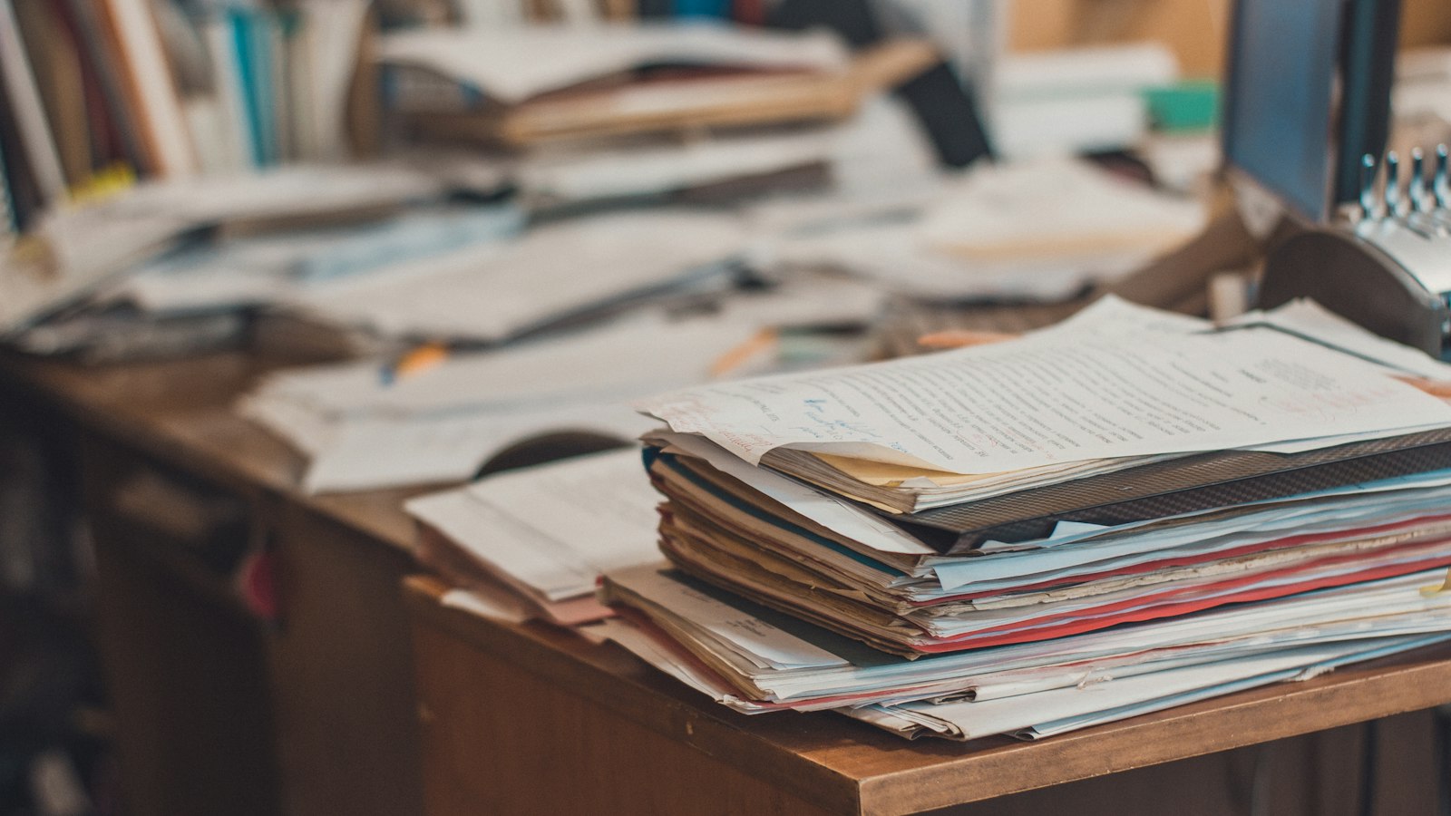 Piles de dossiers sur un bureau en bois : l'article 7 de la convention des entreprises de propreté et l'article L. 1224-1 du Code du travail