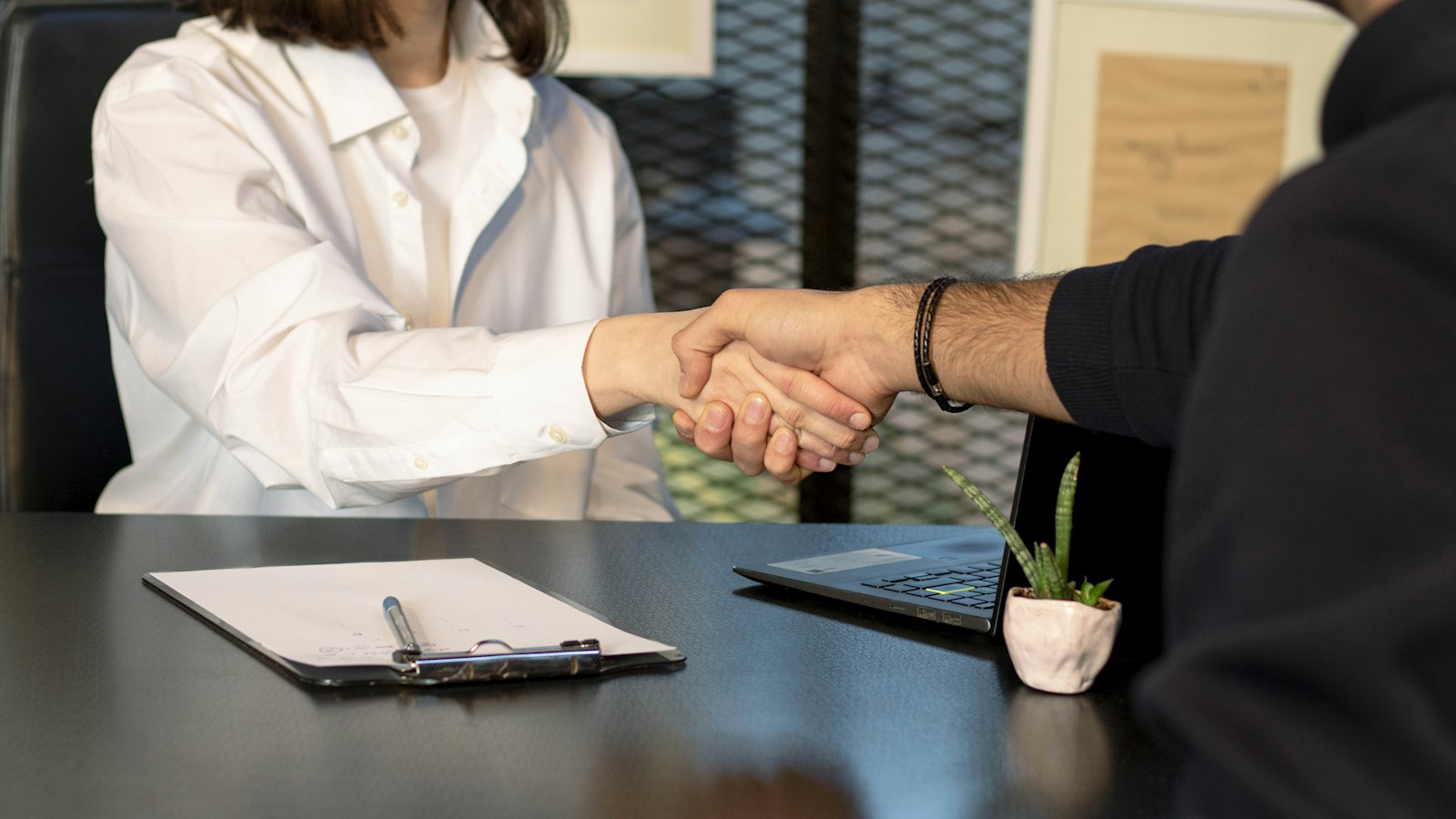 Poignée de main au-dessus d'un bureau : les obligations de l'entreprise sortante et de l'entreprise entrante dans la propreté