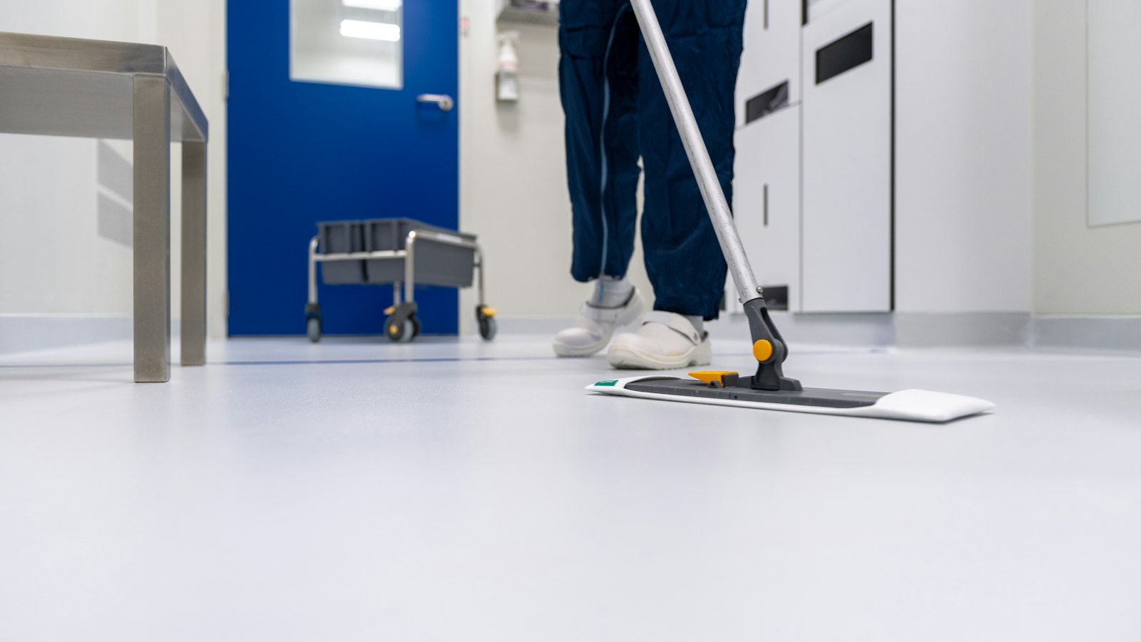 Agent passant le balai à plat dans un couloir : troubles musculosquelettiques et manutention dans la propreté