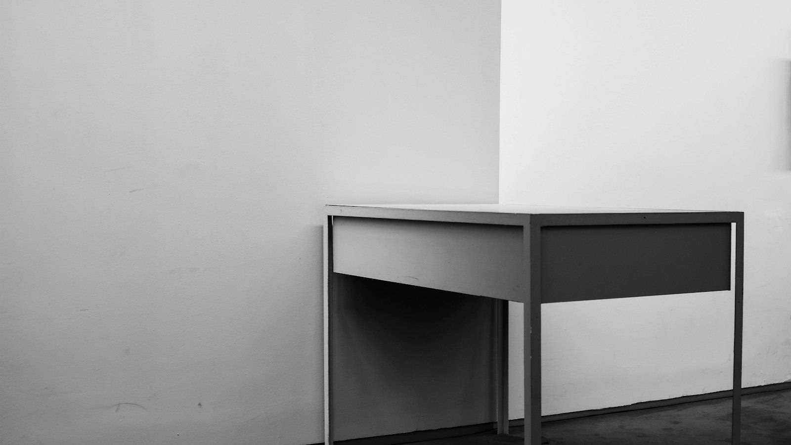 Bureau blanc dépouillé contre un mur nu : l’indemnité légale de licenciement