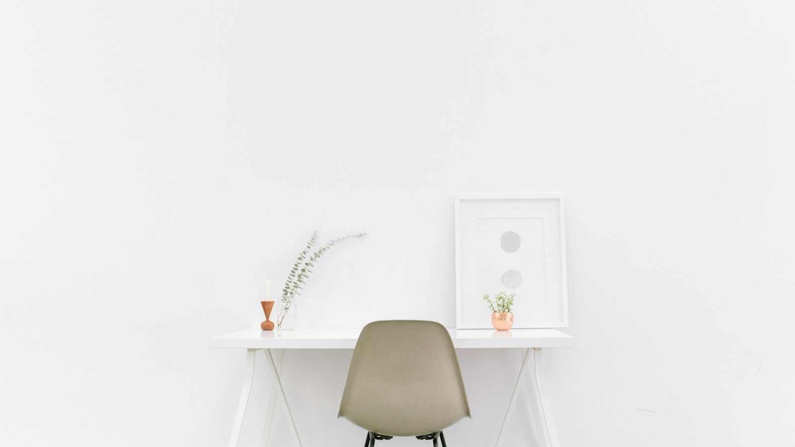 Chaise et bureau blancs dans une pièce vide : les allocations chômage après un départ négocié