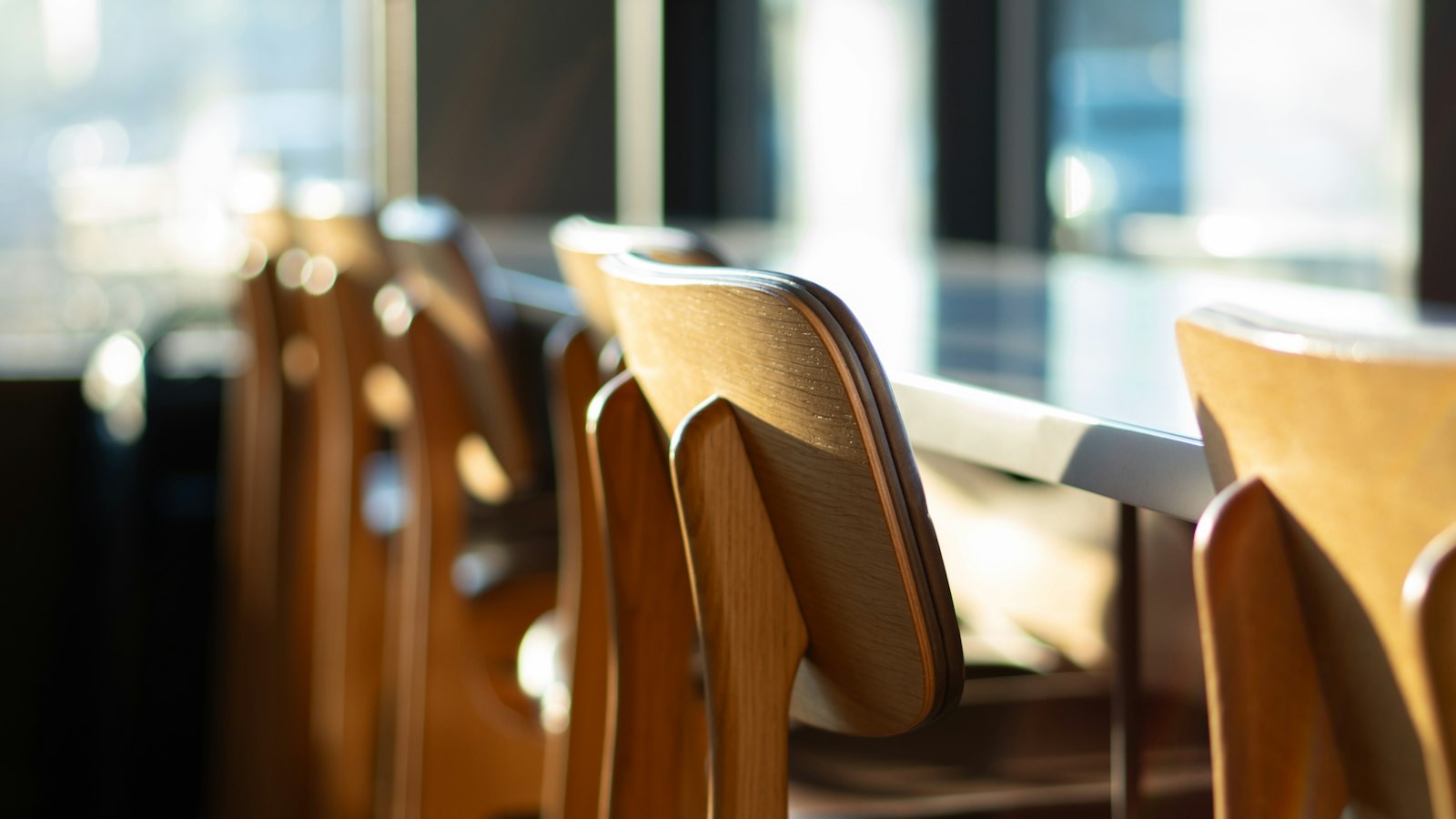 Chaises en bois alignées près d’une fenêtre ensoleillée : les critères d’attribution des activités sociales et culturelles