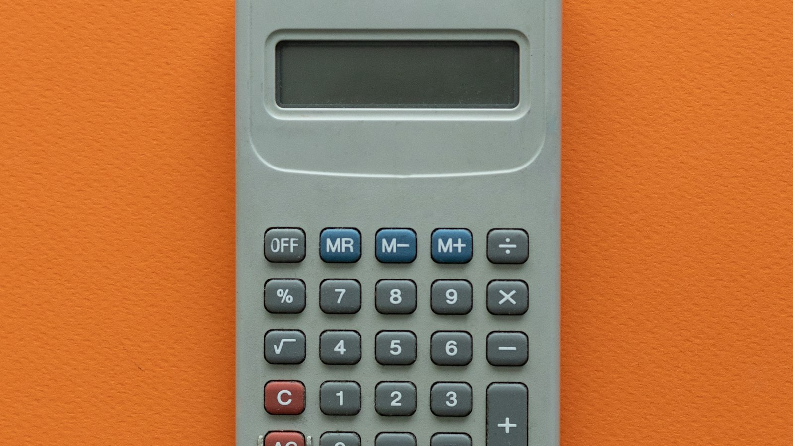 Calculatrice grise sans marque sur fond orange : le budget de fonctionnement du CSE