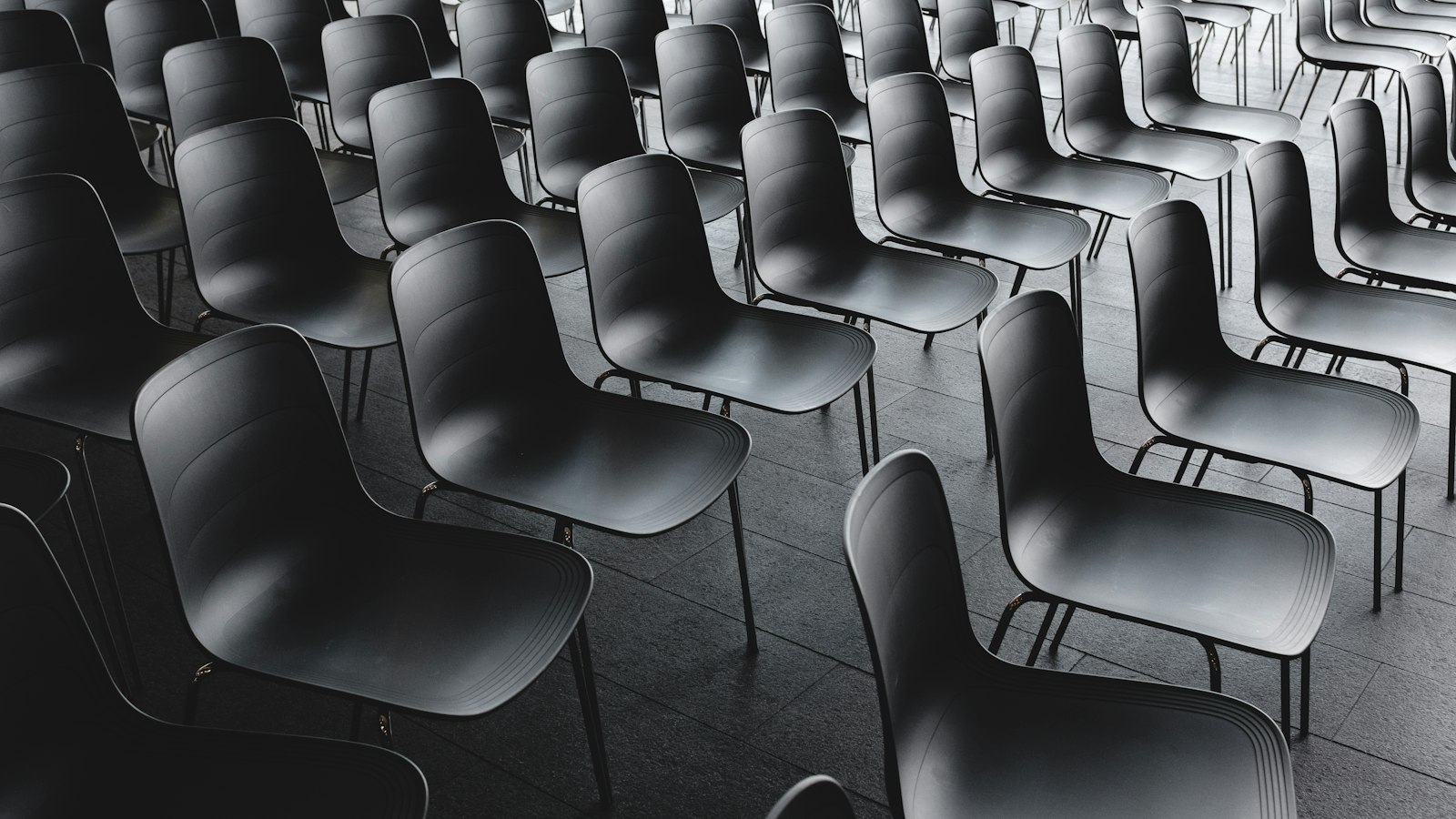 Rangées de chaises noires en noir et blanc : la désignation du secrétaire et du trésorier du CSE