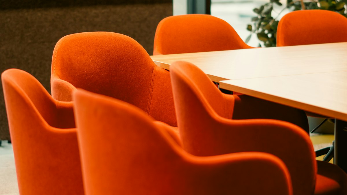 Fauteuils orange autour d’une table de réunion : les réunions du CSE