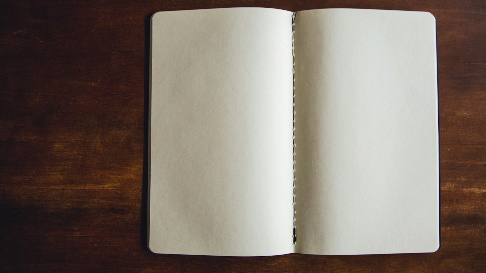 Carnet ouvert aux pages blanches sur une table en bois : le règlement intérieur du CSE