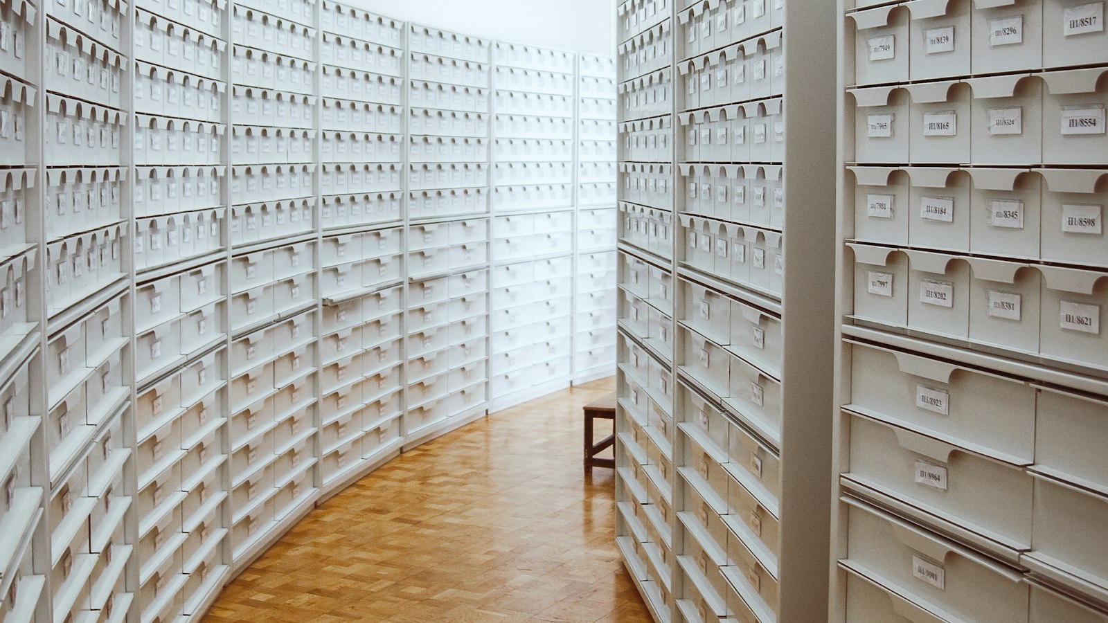 Allée d’archives entre des rayonnages de tiroirs : l’audit social et de la paie