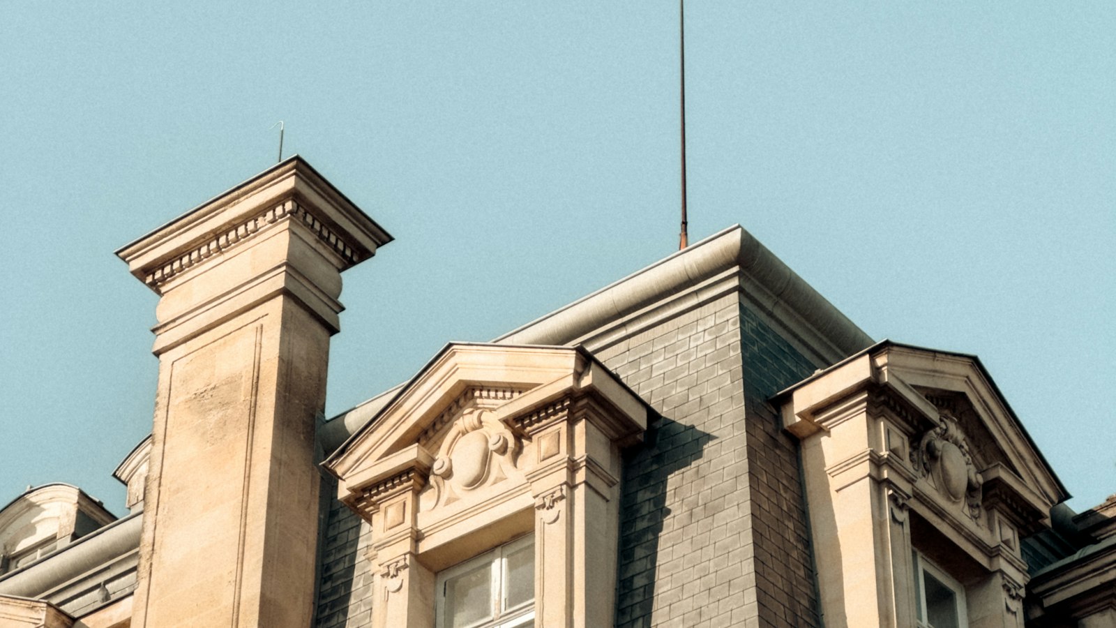 Lucarnes d’un immeuble en pierre sous un ciel bleu : le droit à l’erreur et la régularisation spontanée