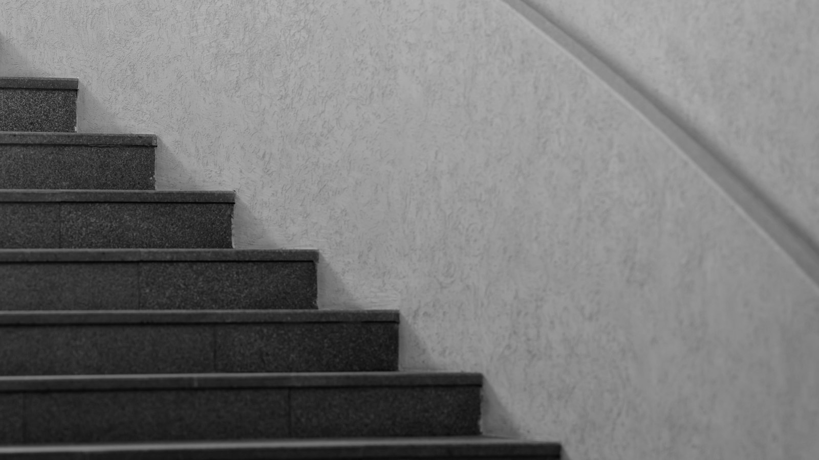 Escalier en noir et blanc montant le long d’un mur courbe : les observations pour l’avenir