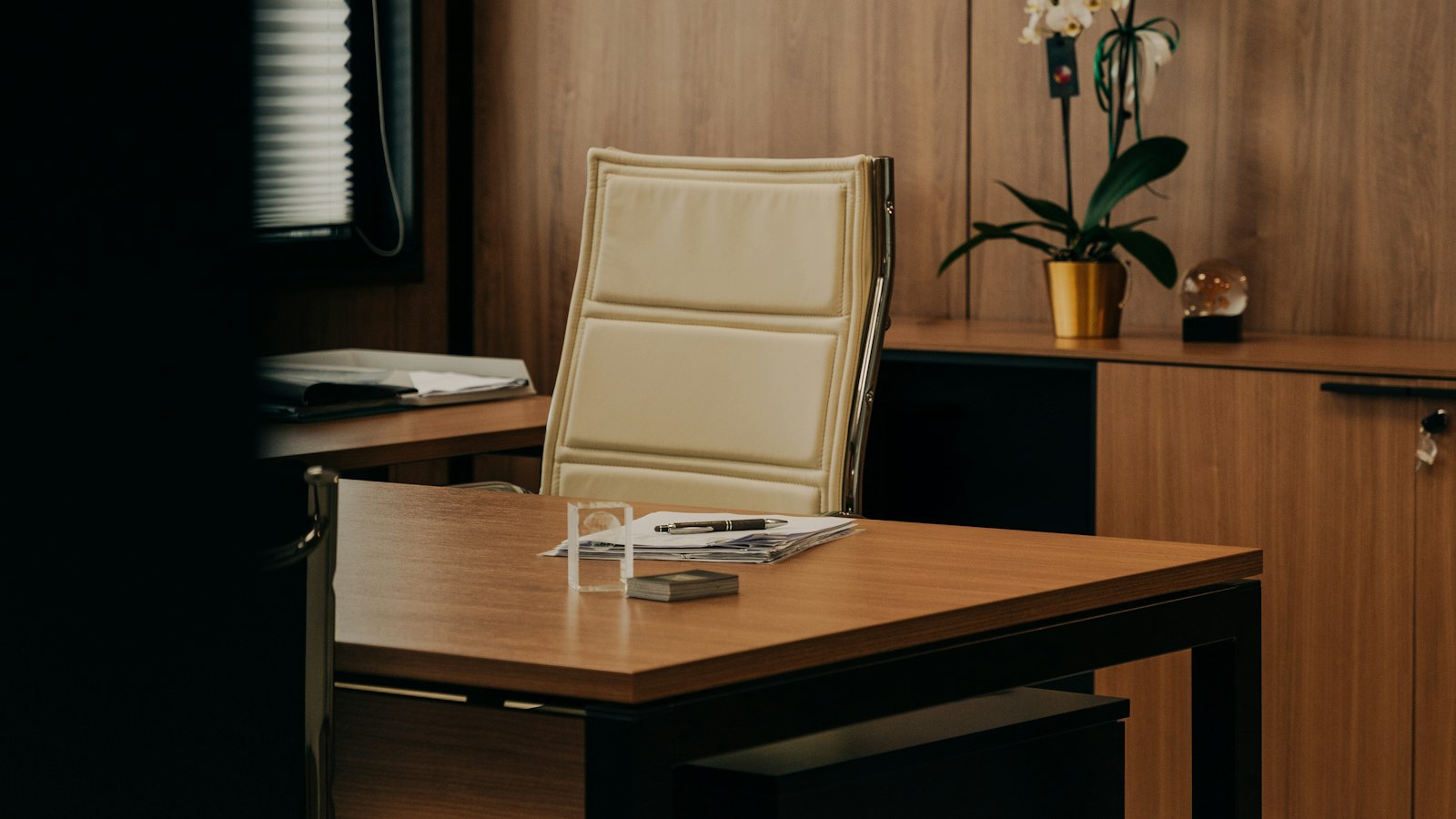 Bureau en bois et fauteuil clair dans une pièce calme : les questions fréquentes sur le gérant de succursale